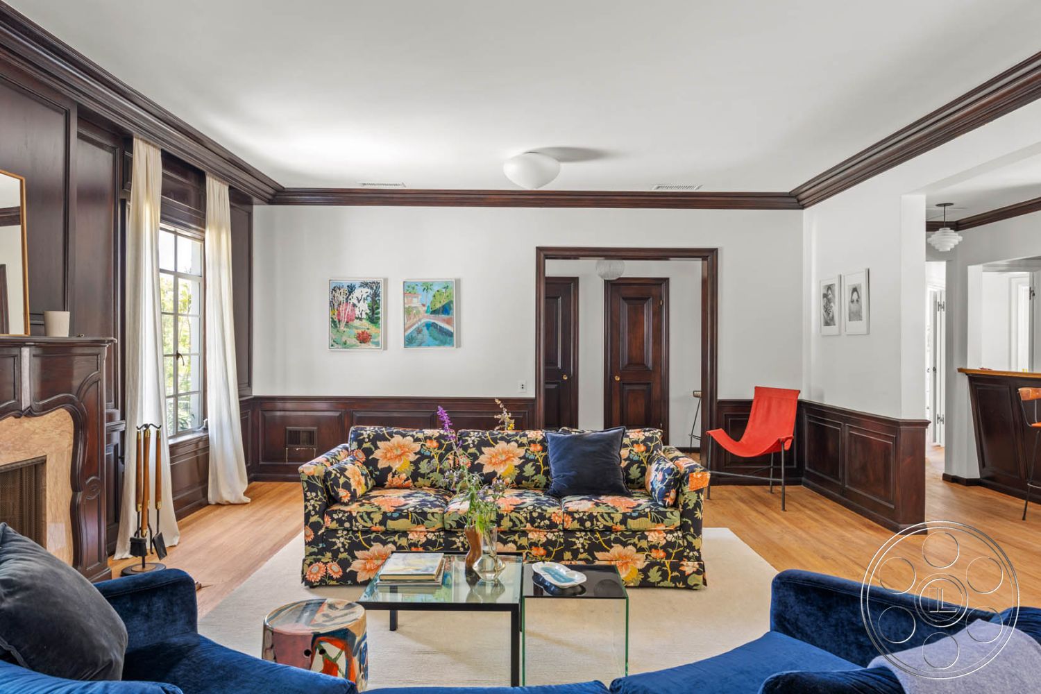 English 60 - glass coffee table, cozy seating arrangement, natural light from large windows, textured plaster walls, floral patterned sofa, modern light fixture, hardwood living room floors, traditional wooden doors, dark wood paneling walls, interior living room, exposed brick fireplace surround, white painted walls, traditional crown molding details, contemporary accent chair, colorful wall artwork, symmetrical room layout