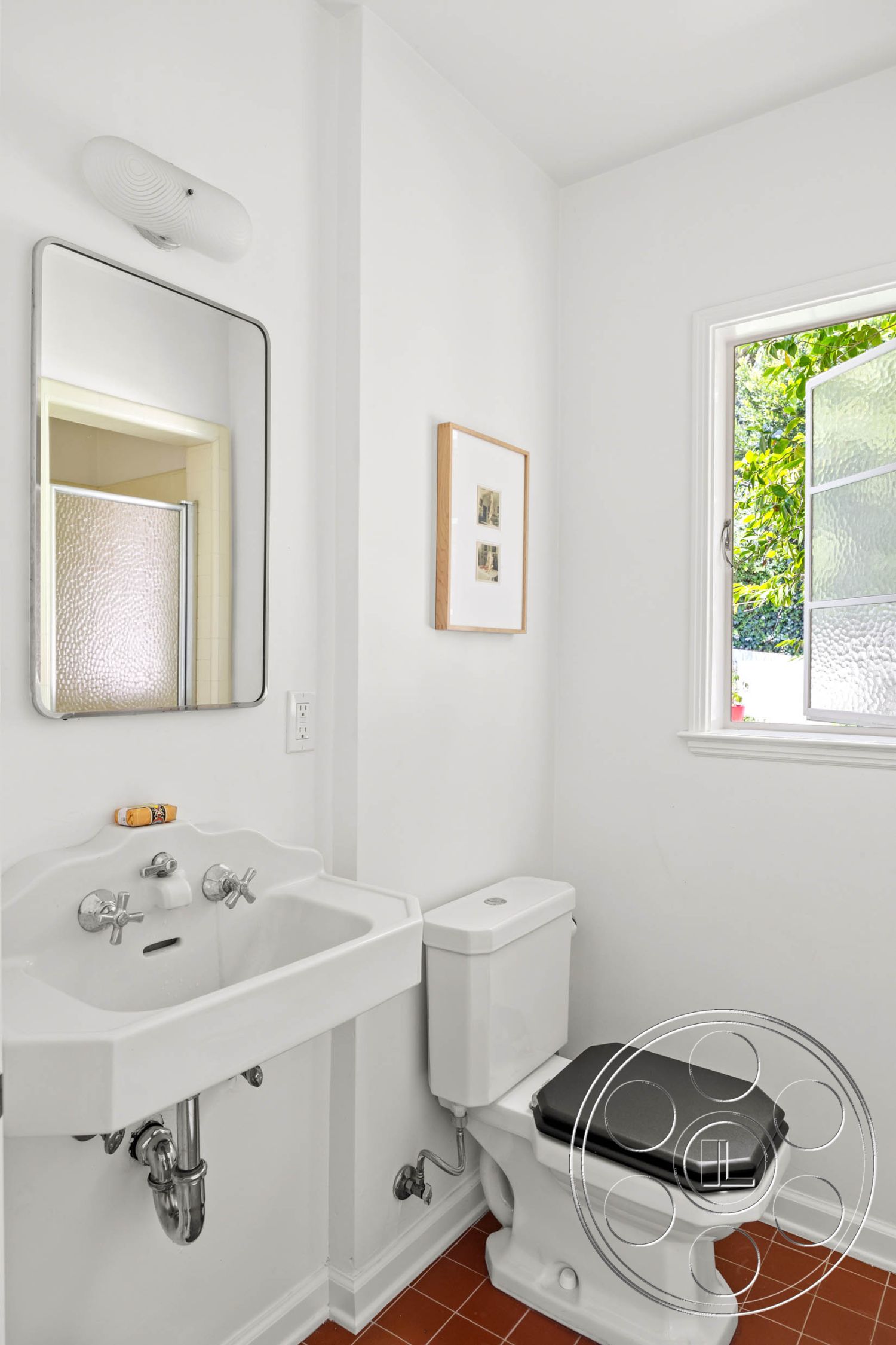 English 60 - neutral color palette, functional space, square tiles, natural light from window, textured glass window, interior bathroom design, contemporary bathroom style, minimalist bathroom decor, white painted walls, glossy ceramic tile flooring, pedestal sink with chrome fixtures, elongated toilet with black seat, modern mirror with simple frame, floor-mounted toilet, simple wall sconce lighting