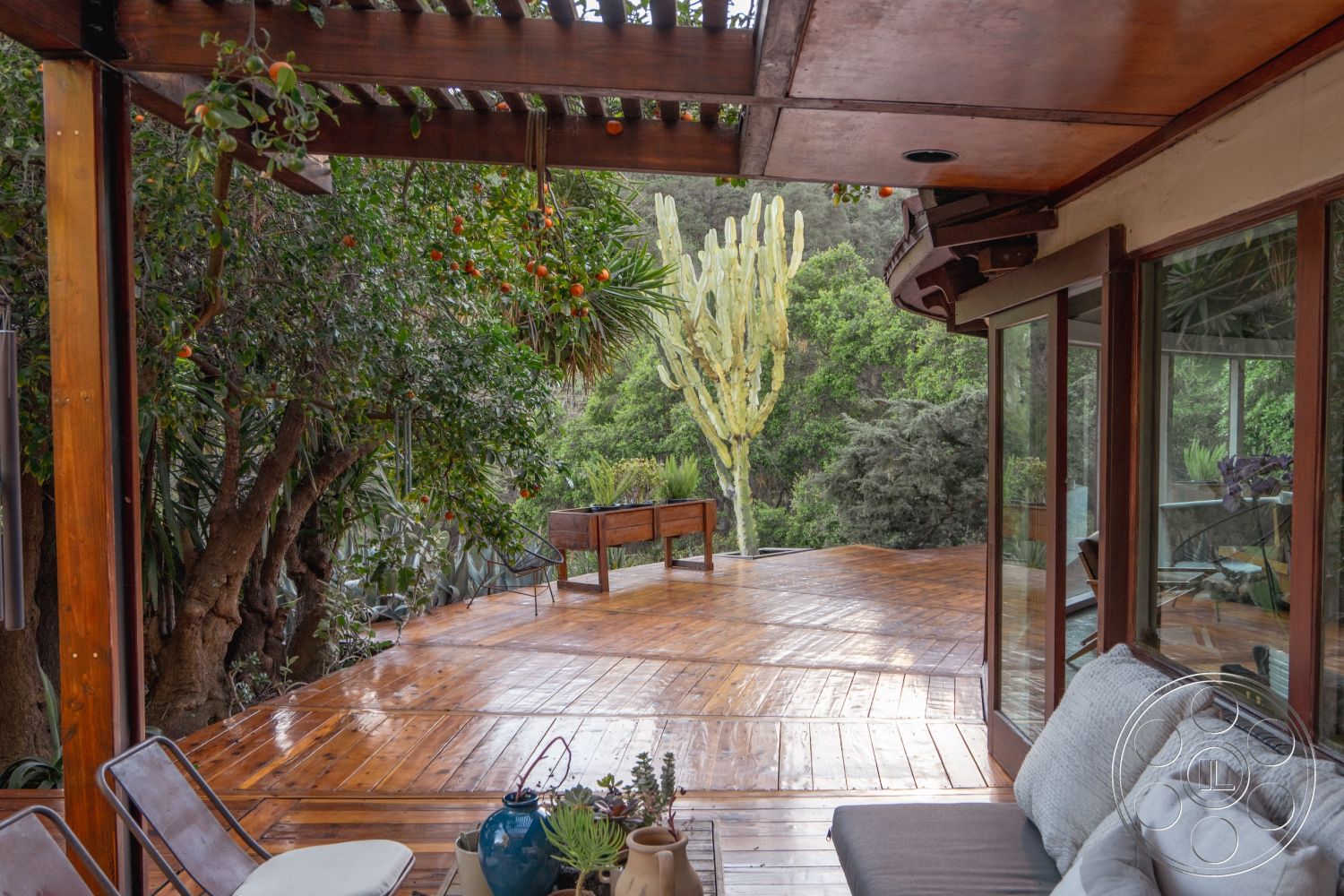 Pad 90210 - sliding glass doors, modern outdoor furniture, tropical plants, open-air living space, eco-friendly materials, naturalistic landscaping, sunlit outdoor area, wooden deck railing, tranquil outdoor retreat, exterior wooden patio floor, exterior hardwood deck, exposed wood pergola, surrounding lush garden setting, rustic wooden bench, textured planted border, weathered wood details, organic garden scenery