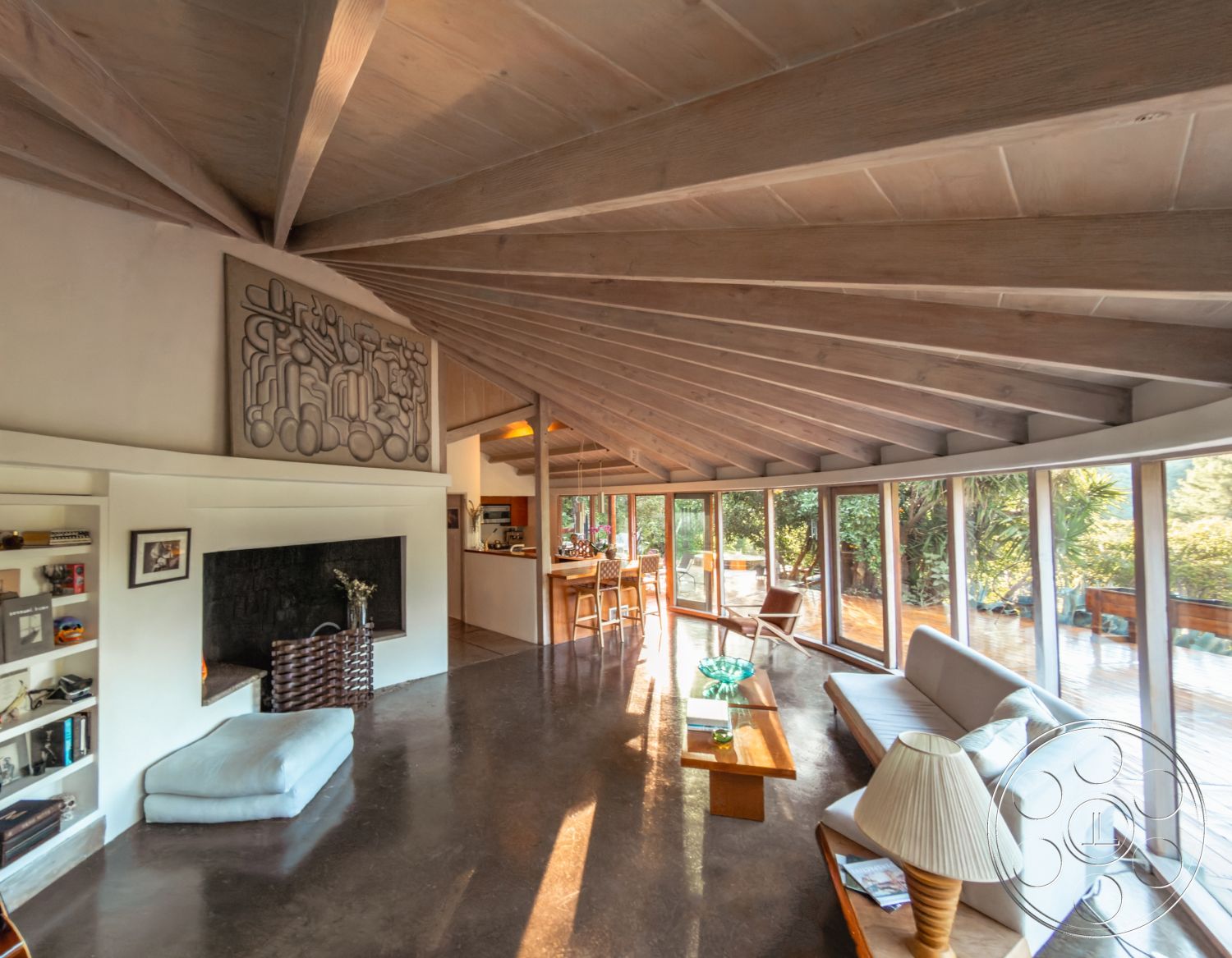 Pad 90210 - exposed wood ceiling beams interior, large floor-to-ceiling windows interior, natural light-filled space interior, contemporary design elements interior, wooden dining table interior, polished concrete living room flooring interior, burnt orange stone fireplace wall interior, curved modern furniture interior, artwork accent wall interior, open floor plan kitchen and living area interior, sliding glass doors leading to garden patio interior, minimalist shelving units interior, textured plaster wall accent interior, ranch-style home architecture, surrounding lush greenery exterior