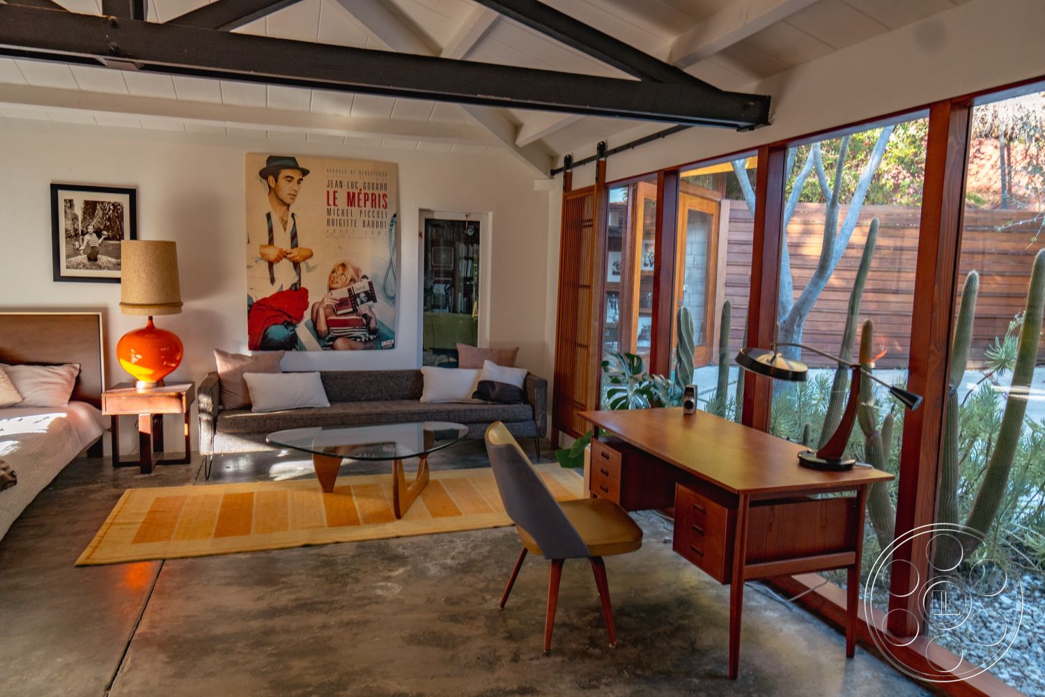 Pad 90210 - textured wall art, glass coffee table, minimalist style, contemporary furnishings, sliding glass door, open concept living space, comfortable seating area, wood frame windows, exposed wood ceiling beams, wood panel accent wall, stylish reading nook, interior concrete floor, modern wooden desk, organic indoor plants, mid-century modern lounge area, retro orange table lamp, soft gray sofa upholstery, bright yellow accent rug, artistic film poster decor, bright, natural light