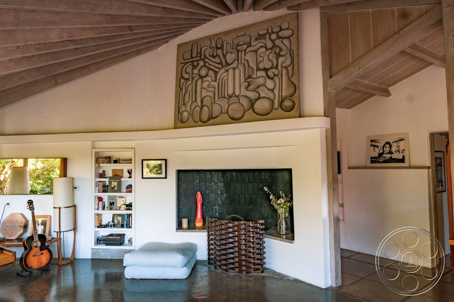 Pad 90210 - open concept layout, reading nook, textured plaster walls, built-in bookshelves, exposed wood ceiling beams, contemporary art decor, natural light filled interior, modern accent furniture, polished concrete living room floor, slate fireplace surround, abstract wall sculpture, large picture window view, vaulted ceiling with wooden accents, minimalistic seating area