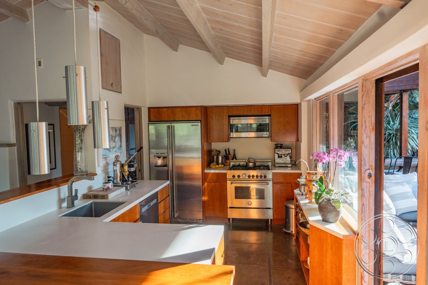 Pad 90210 - minimalist decor, neutral color palette, natural light, open floor plan, stainless steel appliances, wood cabinetry, polished concrete flooring, sliding glass doors, high vaulted ceiling, organic elements, pendant lighting fixtures, modern kitchen design, exposed wood ceiling beams, interior kitchen, concrete kitchen countertops, glass windows with garden view, corner breakfast nook