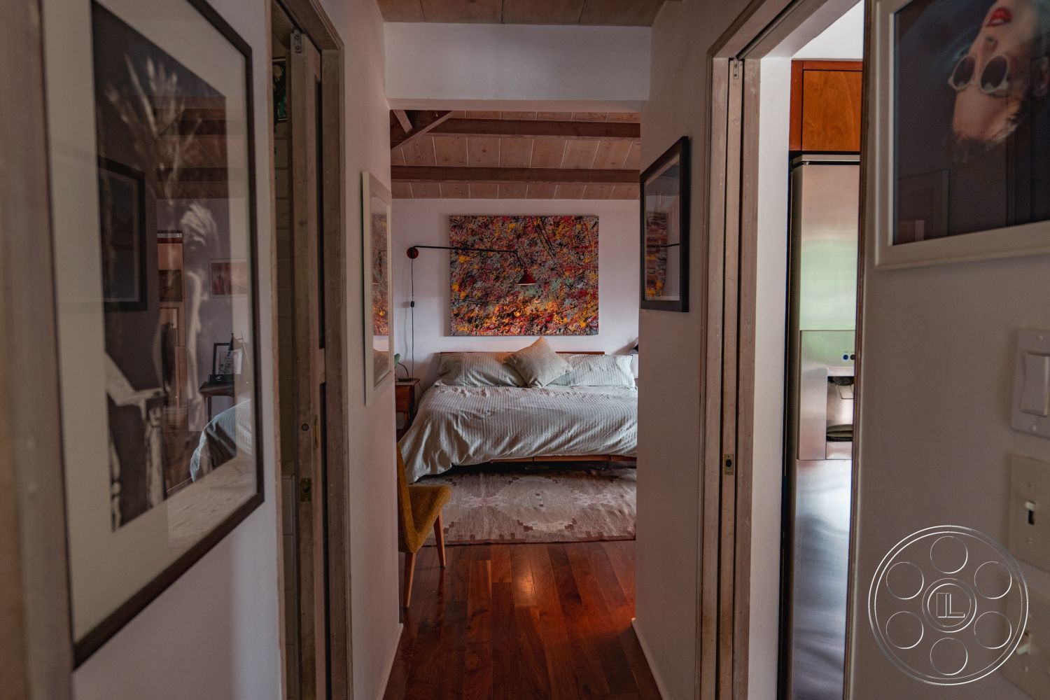 Pad 90210 - interior area rug, interior exposed wood ceiling beams, interior natural light from windows, interior hardwood bedroom floors, interior textured plaster walls, interior framed artwork, interior soft lighting fixtures, interior minimalist bedroom design, interior doorway with wooden trim, interior painted wall accents