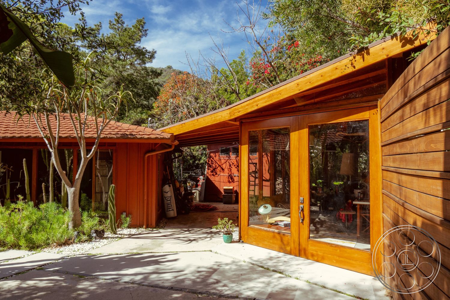 Pad 90210 - landscaped garden setting, exterior concrete patio flooring, exterior glass window panels, exterior wood siding, architectural style Mid-Century Modern, exterior painted red walls, exterior clay tile roofing, exterior wooden double doors, exterior sloped roof, exterior desert vegetation