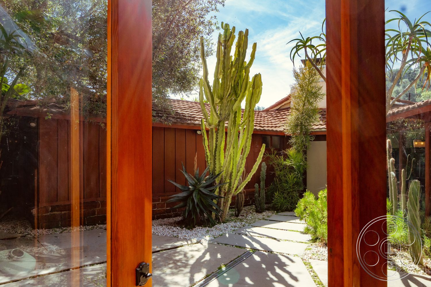 Pad 90210 - red tile roof, concrete stepping stones, pebble ground cover, natural light interior, tropical planting, landscape rock garden, single-story home design, exterior wooden window frames, exterior wooden door frames, cactus garden with succulents, earth-tone wood siding, outdoor garden pathways, modern desert landscaping