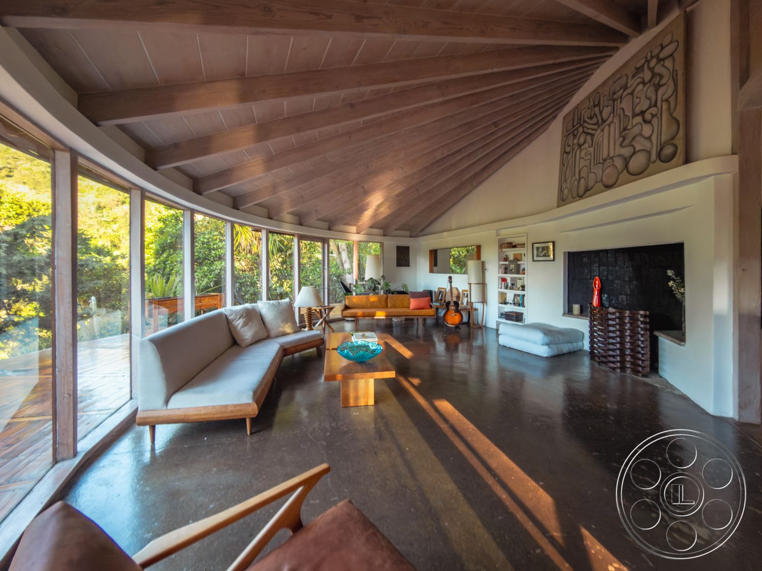 Pad 90210 - natural light, contemporary decor, textured wall art, indoor plants, round coffee table, concrete flooring, floor-to-ceiling windows, outdoor view, bright and airy atmosphere, open living space, wooden accent furniture, stylish seating arrangement, mid-century modern design, exposed wood ceiling beams, built-in shelving units, curved interior walls, integrated fireplace niche