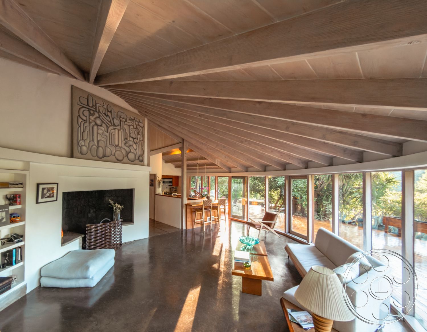 Pad 90210 - floor-to-ceiling windows, bright and airy atmosphere, seamless indoor-outdoor flow, contemporary dining area, nature-inspired decor, exposed wood ceiling beams, natural light-filled space, open concept living area, stone fireplace surround, vaulted living room ceiling, concrete floor finish, surrounded by lush greenery, modern minimalist furniture, white plaster interior walls, modern art wall sculpture, custom built-in shelves, smooth wood ceiling panels, interior wood accents, L-shaped kitchen layout, urban woodland setting