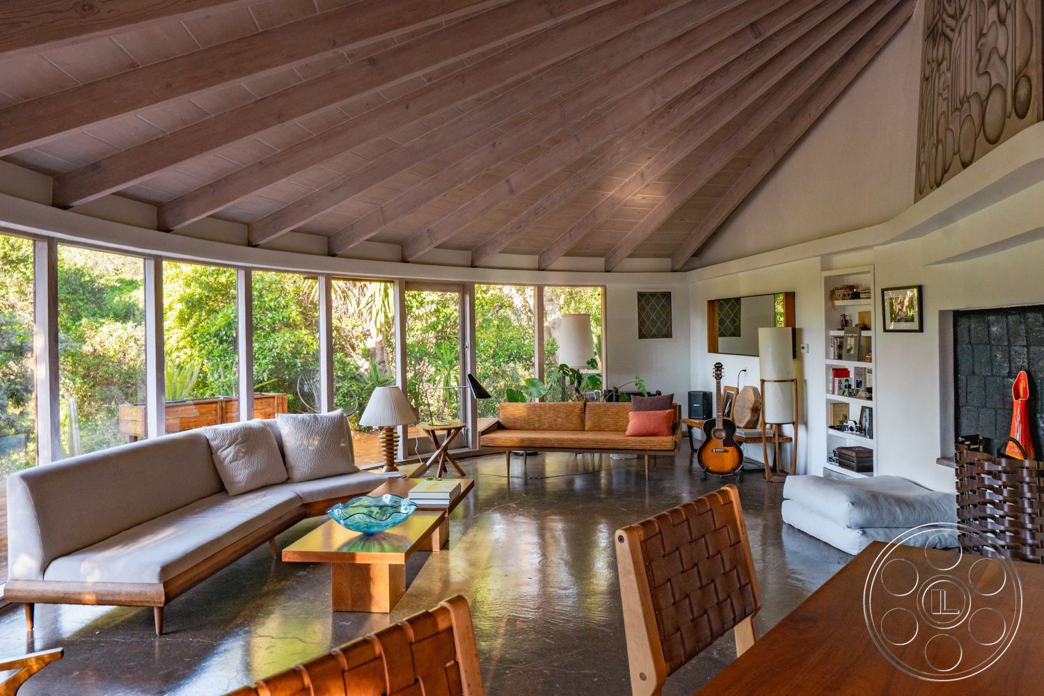 Pad 90210 - neutral color palette interior, exposed wood ceiling beams interior, mid-century modern style interior, large glass windows interior, wooden dining table interior, textured wall finish interior, polished concrete flooring interior, open floor plan living space interior, curved walls interior, natural light-filled living area interior, integrated indoor plants interior, modern wooden coffee table interior, plush fabric sofa with accent pillows interior, cozy seating nook interior, minimalistic decor accents interior, light wood paneling ceiling interior, built-in book shelving interior, geometric decorative elements interior