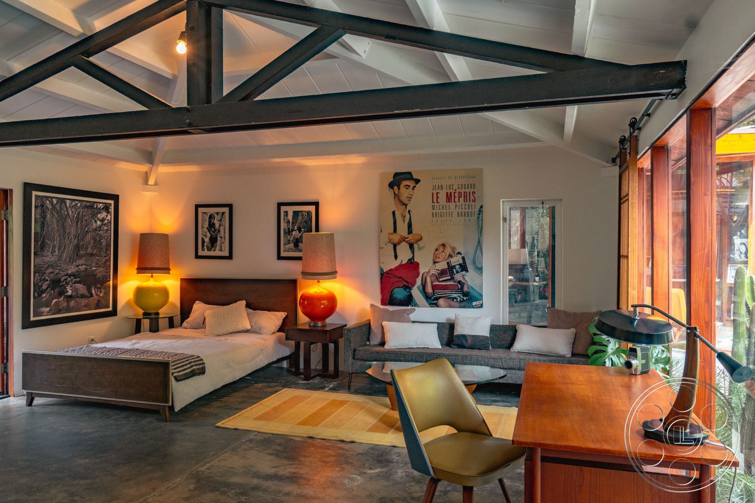 Pad 90210 - glass sliding doors interior, wooden bed frame interior, exposed wood ceiling beams interior, floor-to-ceiling windows interior, open floor plan interior, concrete flooring interior, soft lighting fixtures interior, earthy color palette interior, textured throw pillows interior, indoor plants interior, modern decorative lamps interior, minimalist wall art interior, dark wood furniture interior, designated workspace interior, low-profile sofa interior, stylish accent chair interior, retro movie poster wall decor interior, area rug interior