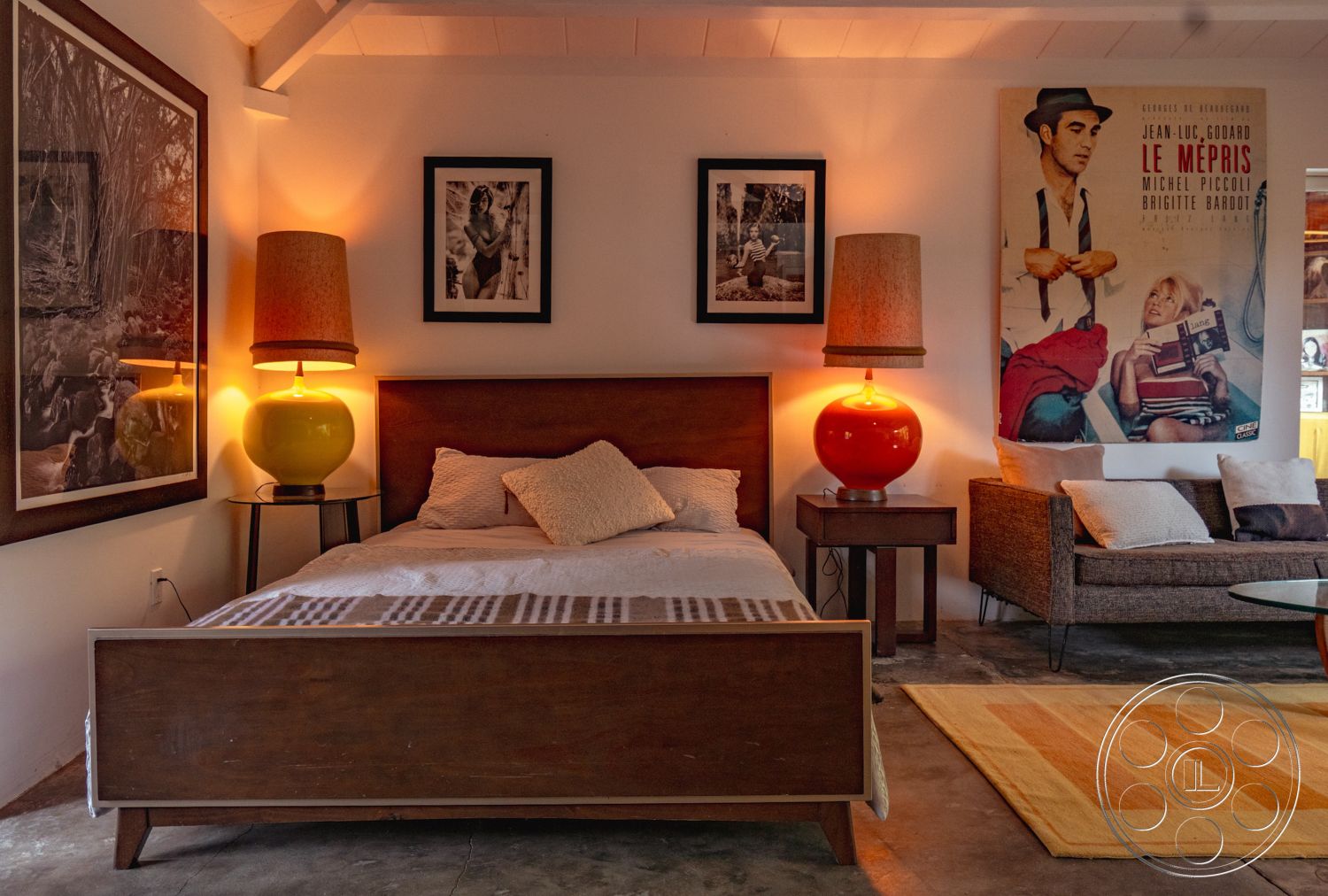 Pad 90210 - textured area rug, open floor plan, modern art wall decor, decorative throw pillows, mid-century modern style, wood bed frame, exposed wood ceiling beams, interior bedroom setting, glass side table, soft lighting accents, concrete bedroom floor, woven sectional sofa, retro table lamps, black and white photo wall art, orange ceramic lamp base, bright accent colors