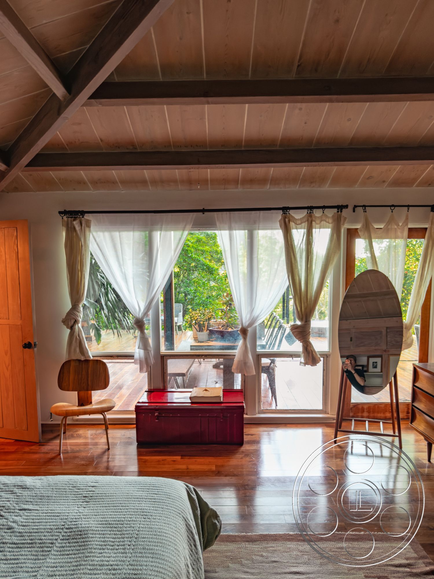 Pad 90210 - natural light interior, hardwood bedroom floors interior, rural farmhouse setting, wood beam ceiling interior, floor-to-ceiling windows interior, textured wall treatment interior, contemporary style interior, outdoor deck view interior, transom window accent interior, light sheer curtains interior, wooden chair accent interior, red storage trunk accent interior