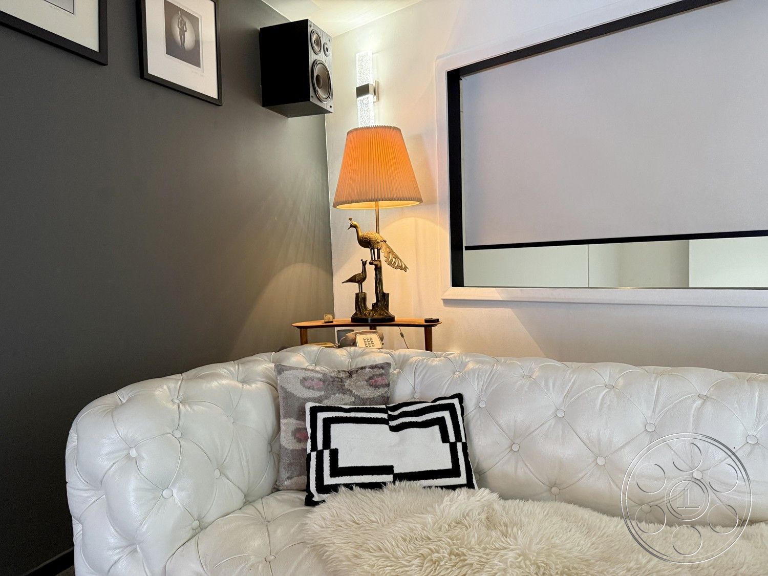 Studio 45 - decorative sculpture, textured throw pillows, wooden side table, black accent wall, modern wall art, exterior features, white tufted leather sofa, tall standing lamp, black-framed window, high-end audio speakers