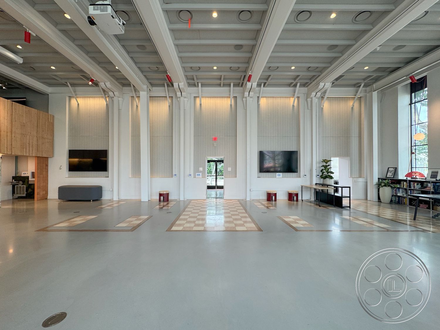 Studio 101 - concrete flooring, large glass windows, interior space, minimalist furnishings, modern architectural style, ambient lighting fixtures, natural light flooding, open layout design, smooth polished concrete floor, vertical wood paneling accents, exposed wooden beams ceiling, functional reception area, plated cabinetry, flexible communal space, checkerboard tile inlay, library shelving units