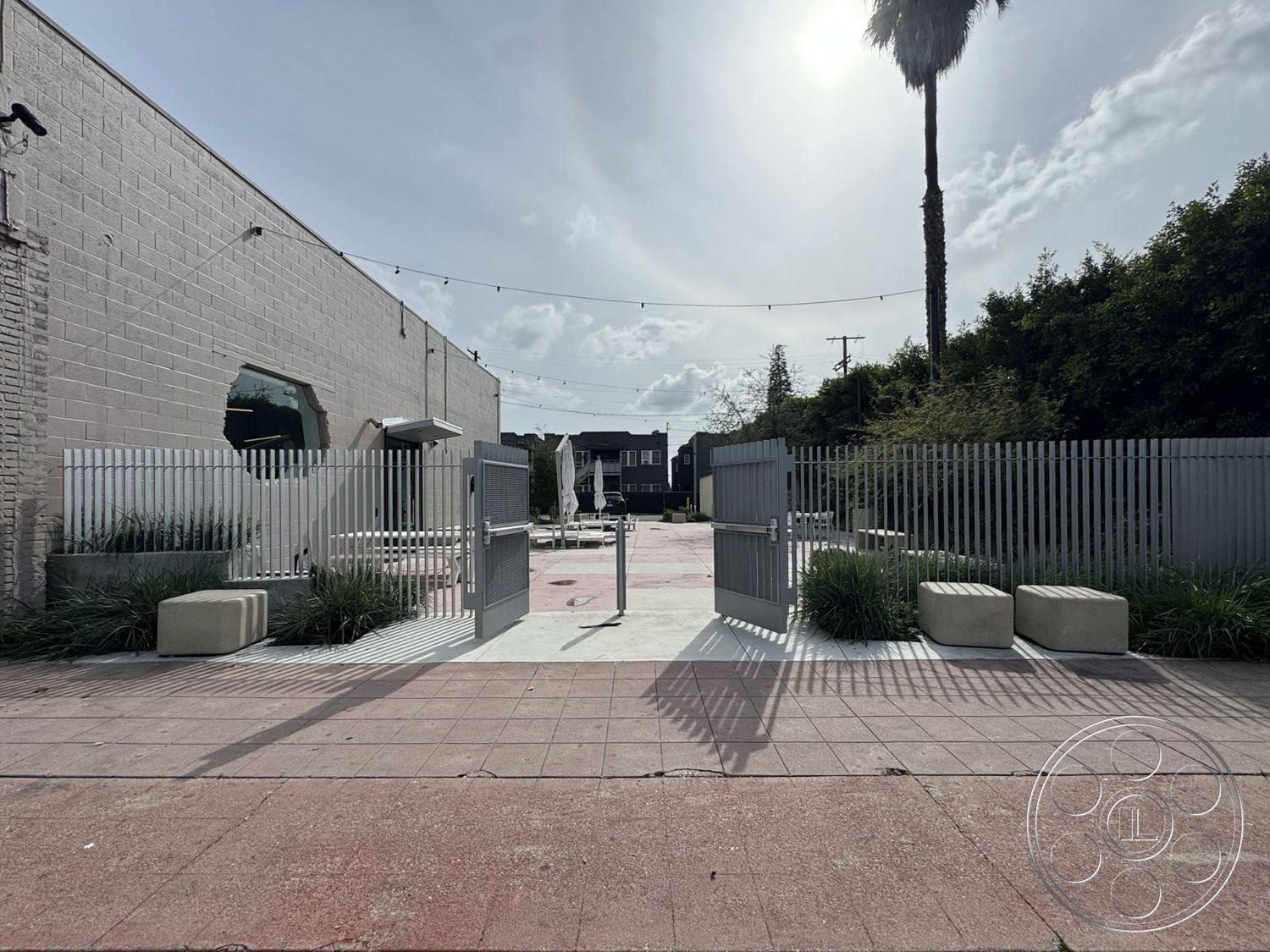 Studio 101 - surrounding greenery, outdoor gathering space, casual seating arrangement, decorative outdoor lighting, textured concrete surface, octagonal window, landscaped garden area, exterior concrete driveway, minimalist architectural style, palm tree landscaping, modern outdoor setting, exterior concrete patio, concrete bench seating, open outdoor area, metal slat fence, striped concrete pavement, urban courtyard design, accentuating natural light, steel gate entrance