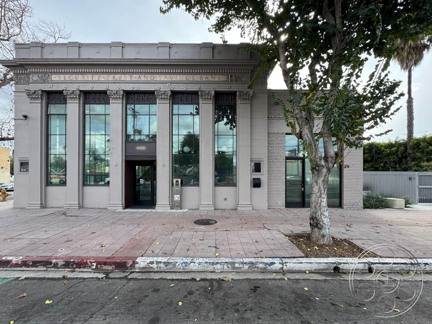 Studio 101 - exterior, symmetrical facade, neoclassical architecture, historical building, concrete sidewalk, landscaped front garden, tall glass windows, paved entryway, brick exterior walls, urban street view, ornate cornice details, decorative pilasters, columned facade, modern glass doors, well-manicured trees, plaza setting
