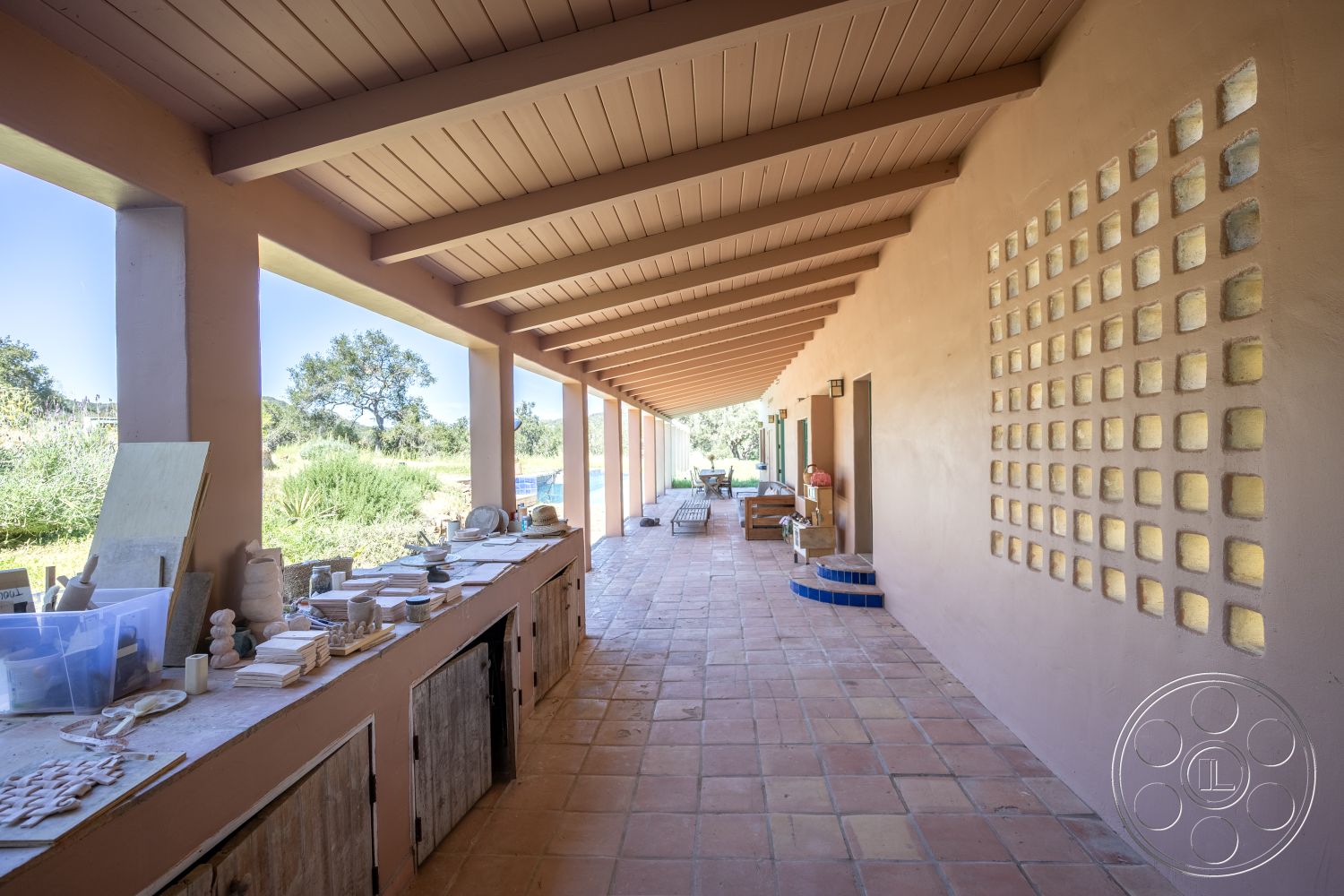 Casa del Rey - exposed beam ceiling, textured plaster walls, stucco wall finish, large windows with garden view, modern outdoor setting, natural landscape surroundings, terra-cotta tile flooring, spacious patio area, exterior courtyard home, built-in outdoor workbench, warm-colored accent wall, open-air studio space