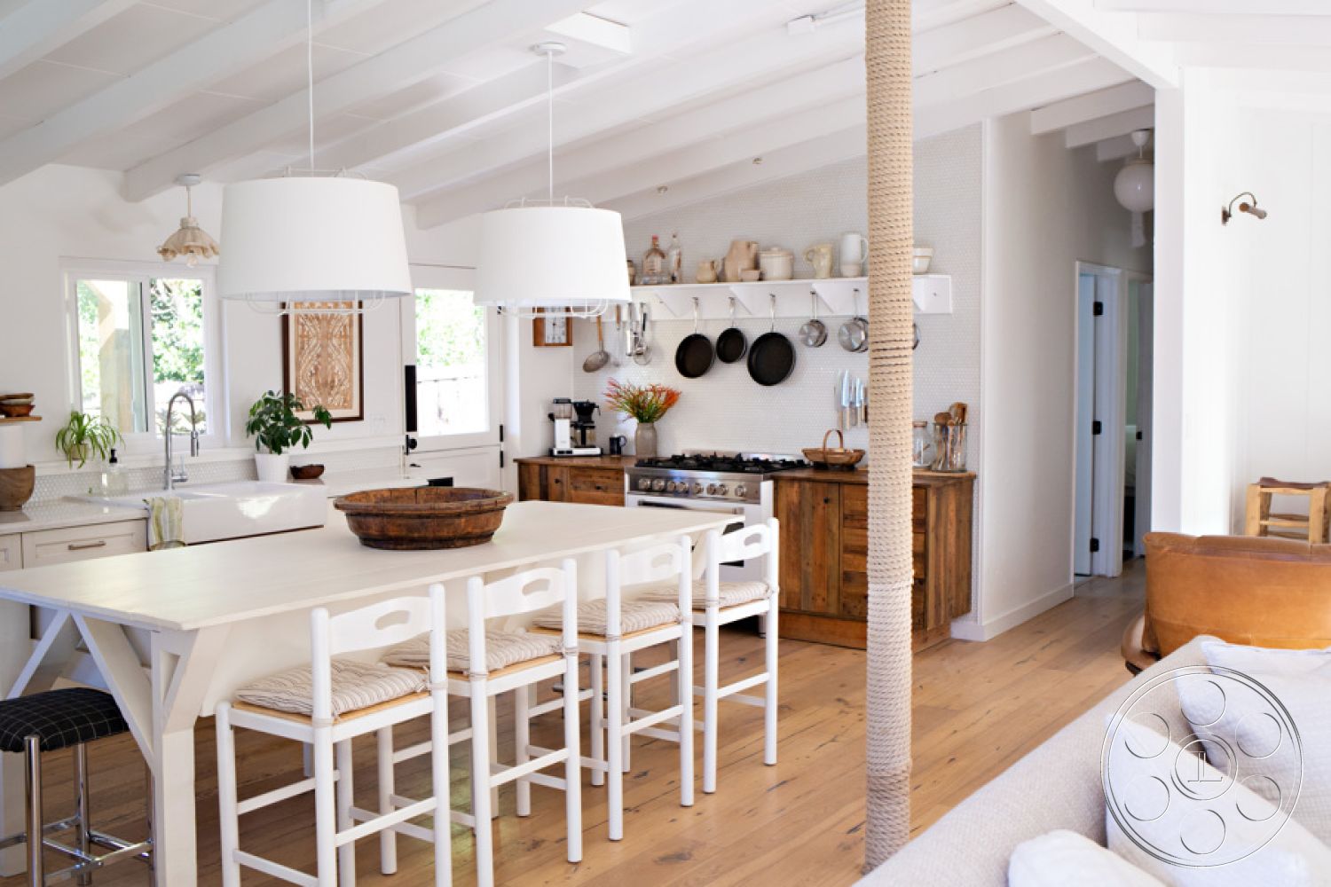 Ranch 33 - open floor plan, stainless steel appliances, farmhouse style, modern kitchen island, textured backsplash, exposed wood ceiling beams, interior kitchen, hardwood kitchen floors, white painted walls, shaker-style kitchen cabinets, natural light abundance, cozy dining area, hanging pendant lighting, lived-in kitchen decor