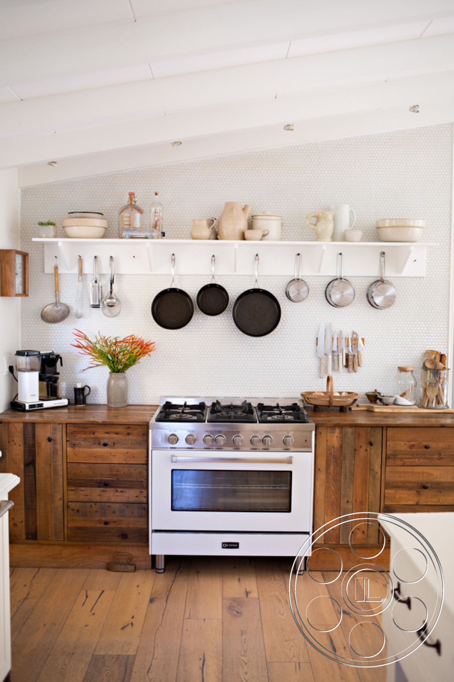 Ranch 33 - light hardwood flooring, textured wall treatment, modern farmhouse style, functional kitchen layout, interior kitchen design, minimalist kitchen decor, white subway tile backsplash, natural wood countertop, reclaimed wood cabinetry, stainless steel gas stove, open shelving with kitchenware, hanging cast iron pans, shelf with decorative pottery, interior kitchen with plants, cozy kitchen ambiance