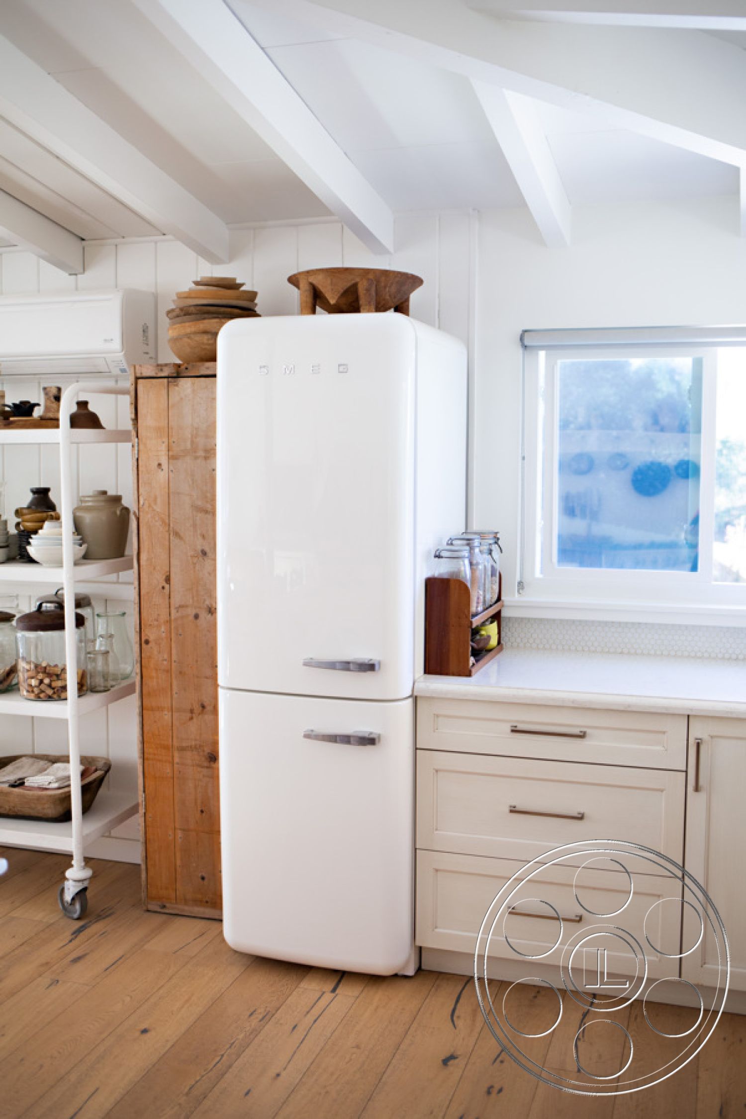 Ranch 33 - exposed wood beam ceiling interior, natural light from window interior, hardwood kitchen floors, contemporary kitchen design interior, metal kitchen appliance, white painted wood walls interior, farmhouse-style cabinetry interior, open shelving unit in kitchen interior, ceramic decorative pottery interior, neutral color palette kitchen interior