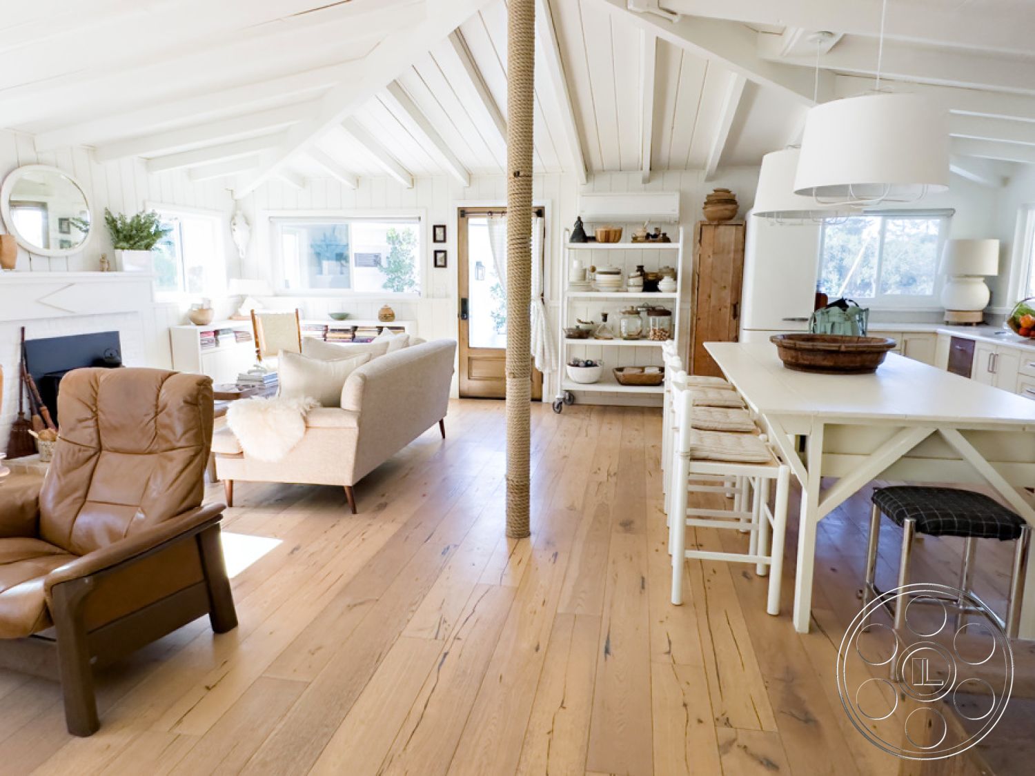 Ranch 33 - neutral color palette, open concept living room, bright and airy atmosphere, rustic wooden door, exposed wood ceiling beams, interior hardwood flooring, natural light-filled space, farmhouse style decor, minimalist dining table, modern farmhouse kitchen, vaulted ceiling with skylights, white shiplap wall treatment, light-colored wood dining chairs, cozy leather armchair, decorative open shelving, textured living room accents, light fixture with clean lines, contemporary living area layout, inviting relaxing corner, clutter-free workspace, stylish kitchen appliances