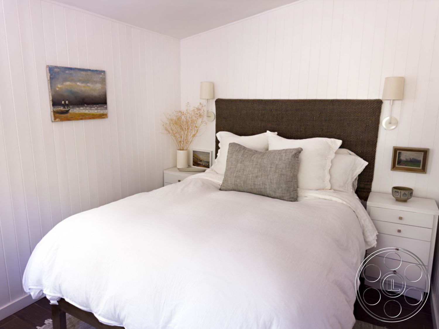 Ranch 33 - neutral color palette, decorative wall art, soft lighting fixtures, interior bedroom, cozy bedroom atmosphere, hardwood bedroom floors, minimalist nightstand, natural light sources, modern accent pillows, contemporary bedside lamps, dried floral arrangement, textured shiplap walls, woven fabric headboard, crisp white bedding, compact storage solutions