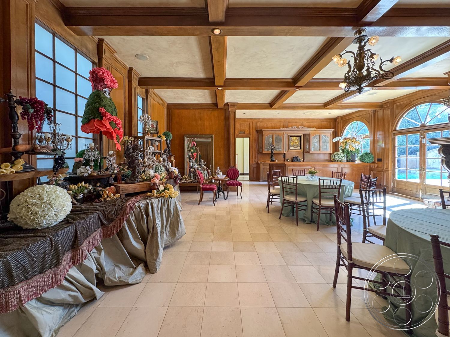 Mansion 146 - bright natural light, large arched windows, stylish accent chairs, exposed wood ceiling beams, open layout design, custom built-in cabinetry, elegant chandelier lighting, marble tile flooring, decorative wall mirror, natural wood paneling walls, furniture with upholstered seats, traditional dining area, soft pastel table linens, ornate decorative vases, formal seating arrangement, flower arrangements for decor, luxurious interior design