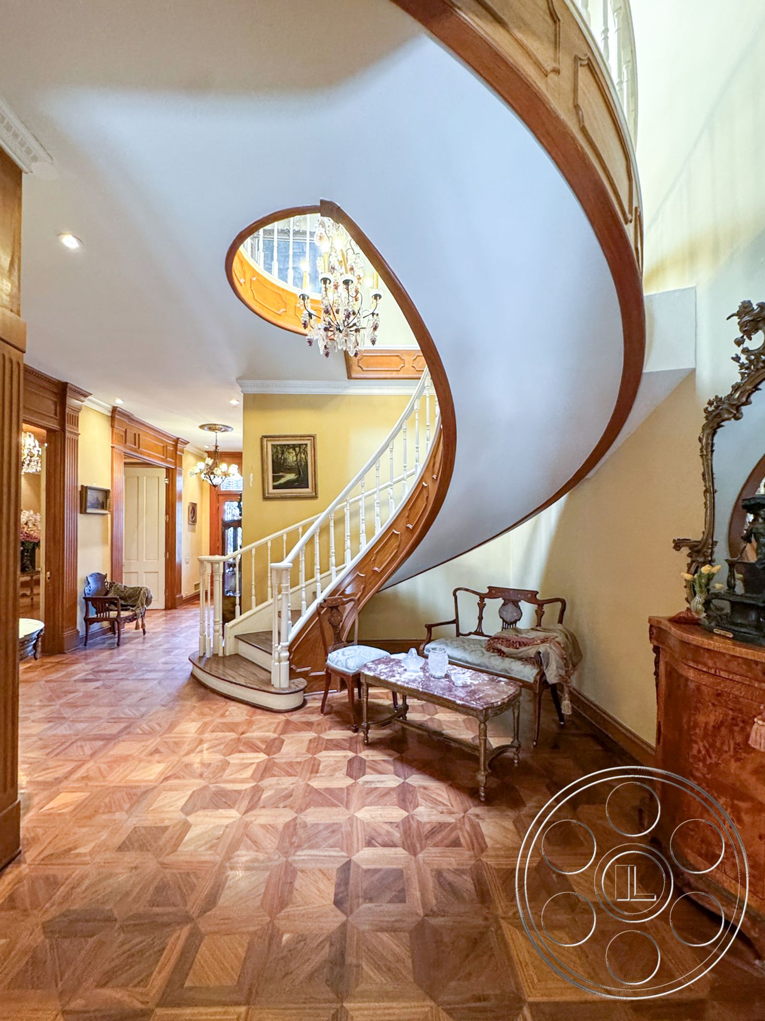 Mansion 146 - open floor plan, arched doorway, elegant wall art, wooden handrail, parquet hardwood flooring, intricate chandelier lighting, light yellow painted walls, detailed crown molding, historical architectural style, exterior curved staircase, ornate wooden paneling, classic furniture pieces, vintage glass coffee table, welcoming foyer area