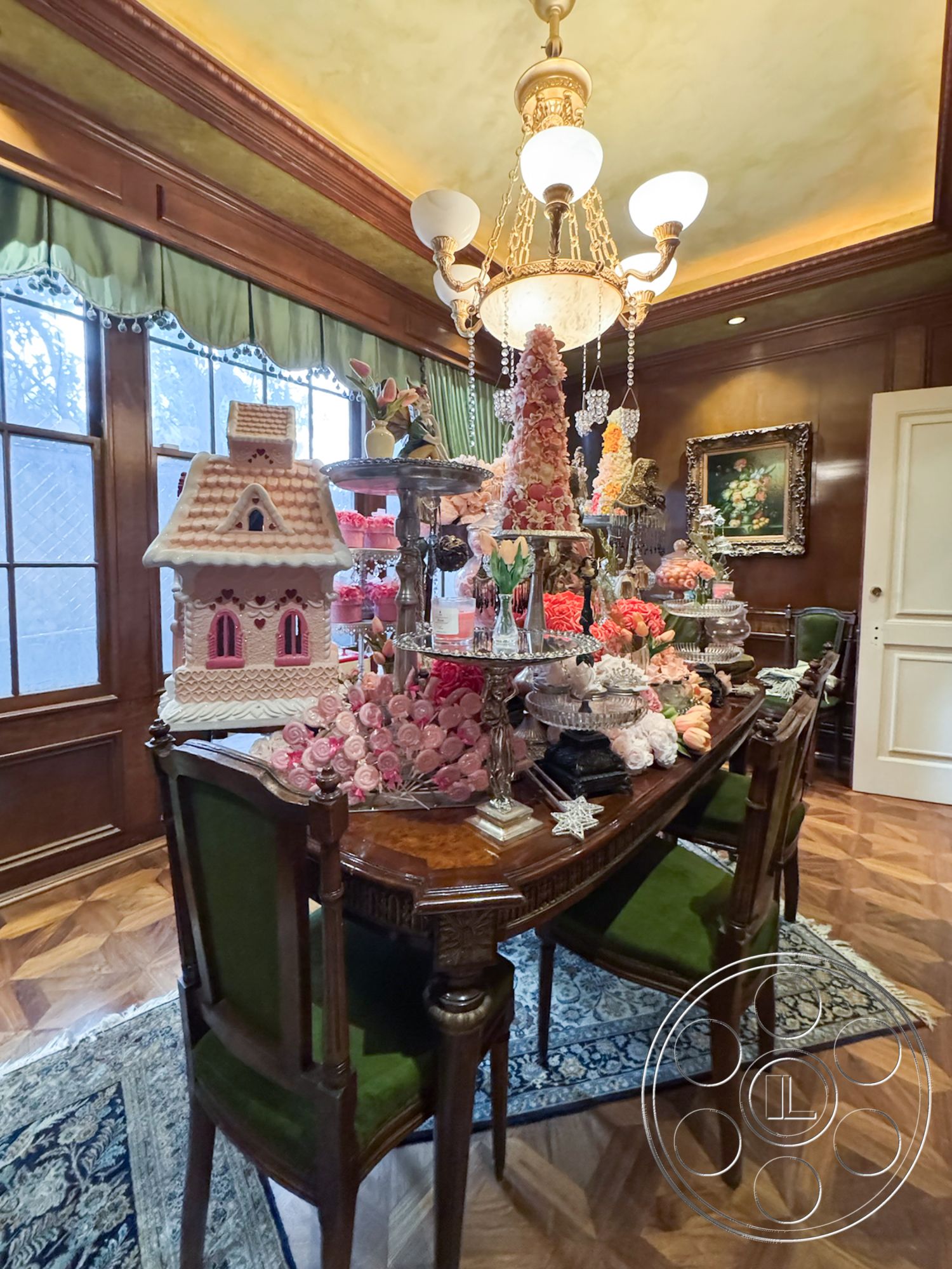 Mansion 146 - dark wood paneling, plush area rug, elegant dining table, decorative floral arrangements, interior dining room, ornate vintage chandelier, herringbone patterned hardwood floors, richly upholstered green dining chairs, glass display stands, decorative cake displays, intricate wall molding, French-style windows, moody warm lighting, lush fabric curtain drapes, vintage artwork on walls