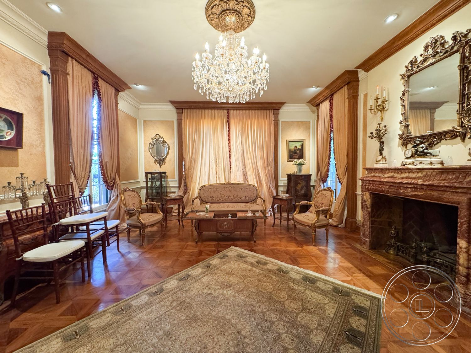 Mansion 146 - textured plaster walls, decorative area rug, ornate chandelier, interior space, marble fireplace surround, elegant sofa, gold-framed mirror, hardwood parquet flooring, silk drapery, wood crown molding details, two-tone wall colors, intricate wall molding, traditional armchairs, vintage side tables, antique decor accents, crystal candelabras, classic art pieces, French window treatments, old money