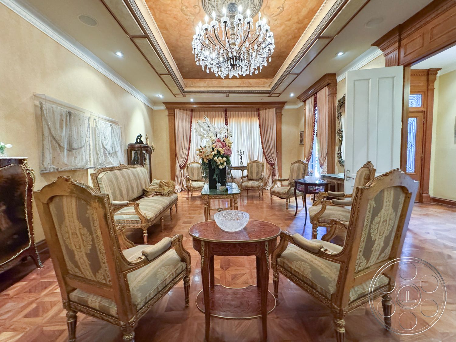 Mansion 146 - interior recessed lighting fixtures, interior decorative crown molding, interior upholstered armchairs, interior elegant floral arrangements, interior antique wooden furniture, interior ornate chandelier, interior polished hardwood floors, interior gilded ceiling details, interior silk drapery window treatments, interior marble-topped coffee table, interior warm beige painted walls, interior vintage carved wood side tables, interior ornate wall decorations, interior classic decorative accents