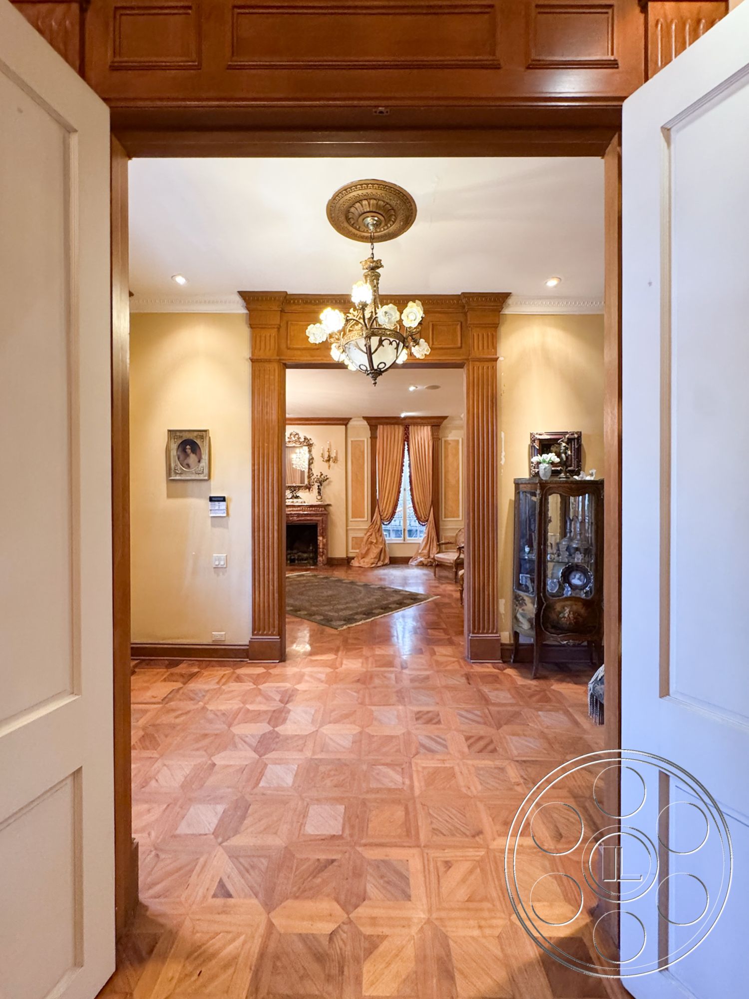 Mansion 146 - decorative wall art, open concept living space, arched doorways, luxurious living room, rich wood paneling, neutral painted walls, crown molding details, framed artwork on walls, interior wooden door frame, traditional fireplace surround, ornate chandelier lighting, intricate ceiling details, exterior classic architecture, polished hardwood entryway flooring, geometric patterned parquet floor, room with elegant drapery, vintage decorative accents, classic style interior, wooden mantlepiece, formal entry foyer