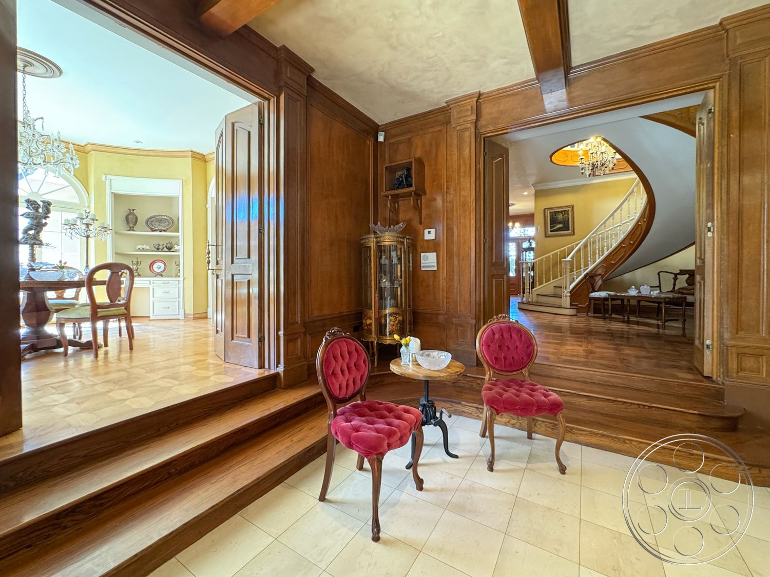 Mansion 146 - interior hardwood flooring, interior coffered ceiling details, interior open floor plan, interior decorative crown molding, interior wood paneling walls, interior traditional architectural style, interior warm color palette, interior ornate chandelier lighting, exterior curved staircase, interior glass display cabinet, interior vaulted ceilings with wood beams, interior marble entryway flooring, interior round dining table with wood accents, interior antique furniture, interior textile upholstery on chairs, interior light-filled living space, interior staircase with decorative railings, interior sunlit dining area, interior sitting area with accent table, interior art displayed on walls