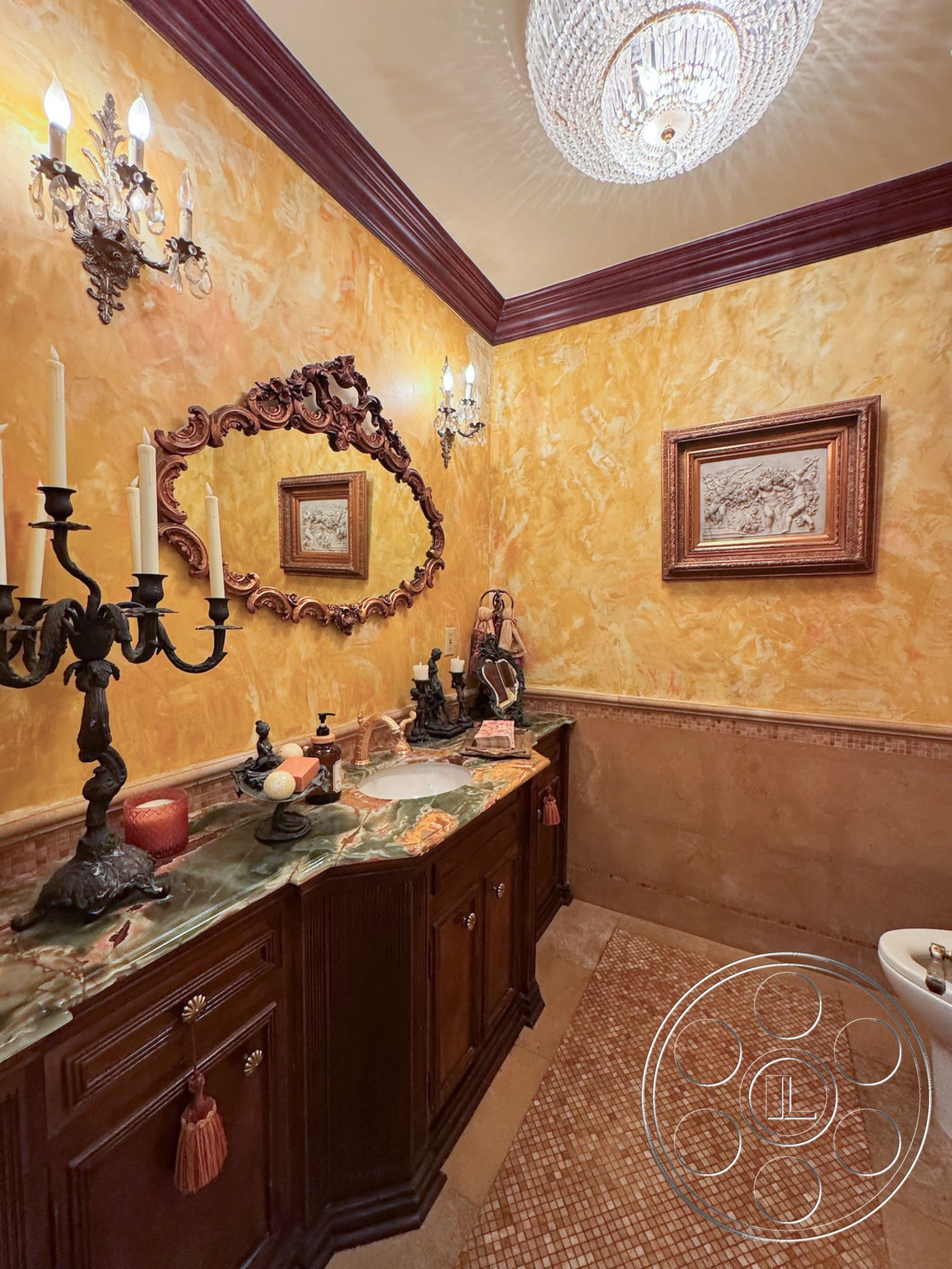 Mansion 146 - interior marble bathroom countertop, interior crown molding details, interior wall treatments with textured plaster finish, interior dark wood vanity cabinetry, interior crystal chandelier lighting, interior decorative wall mirrors with ornate framing, interior mosaic tile flooring, interior wall-mounted candle sconces, interior cream-colored walls with gold accents, interior vintage art decor, interior plush bathroom rug, interior sink with traditional faucet design