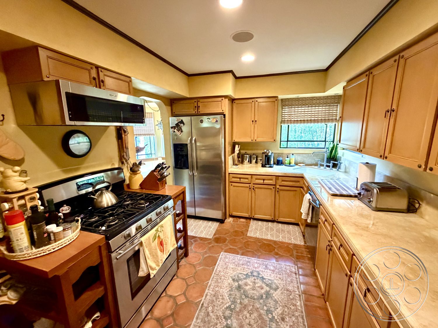 Medit 167 - natural light, wooden cabinetry, kitchen island, marble countertop, decorative rug, earth-toned wall color, stainless steel refrigerator, interior kitchen, stainless steel gas range, crown molding details, open shelving kitchen, double-hung window, terrazzo tile kitchen floor, modern kitchen hood, chefs kitchen