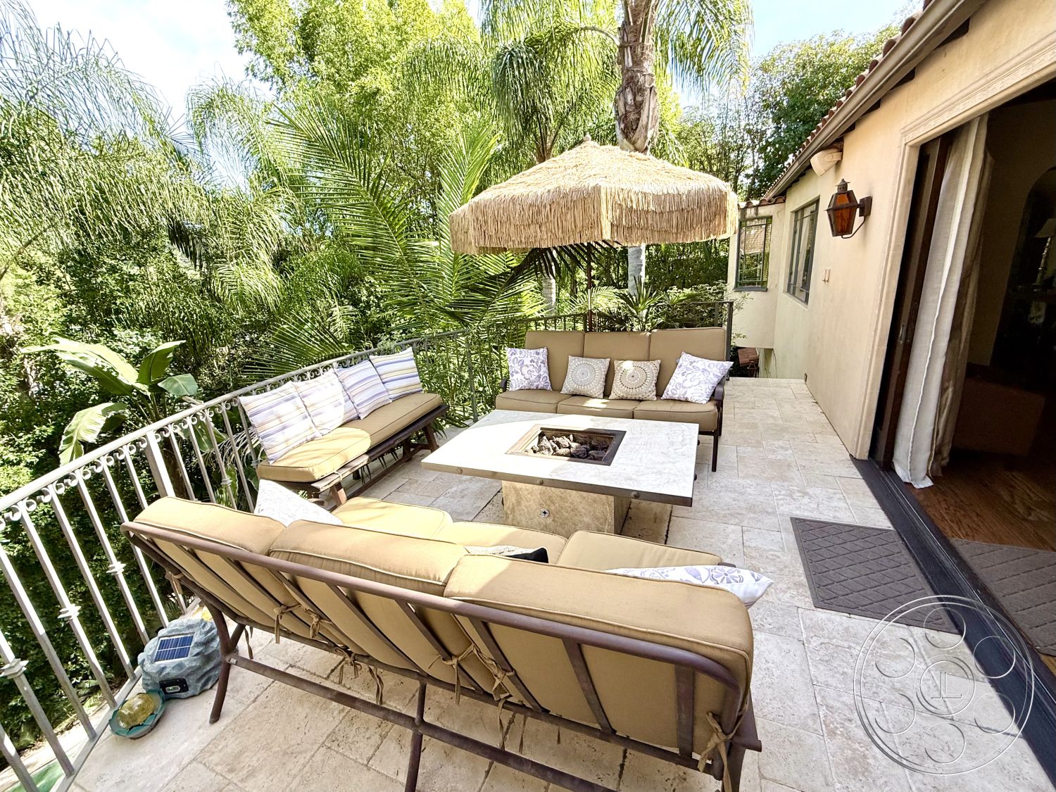 Medit 167 - textured stone wall, open-air living space, decorative throw pillows, greenery backdrop, modern outdoor seating, exterior patio area, rectangular patio layout, palm tree landscaping, natural stone patio flooring, metal railing balcony, multiple seating arrangements, contemporary home exterior, tropical foliage surroundings, woven straw umbrella, fabric outdoor cushions, fire pit table with stone base, wooden framed sliding doors, sunlit outdoor retreat, relaxed outdoor entertaining area