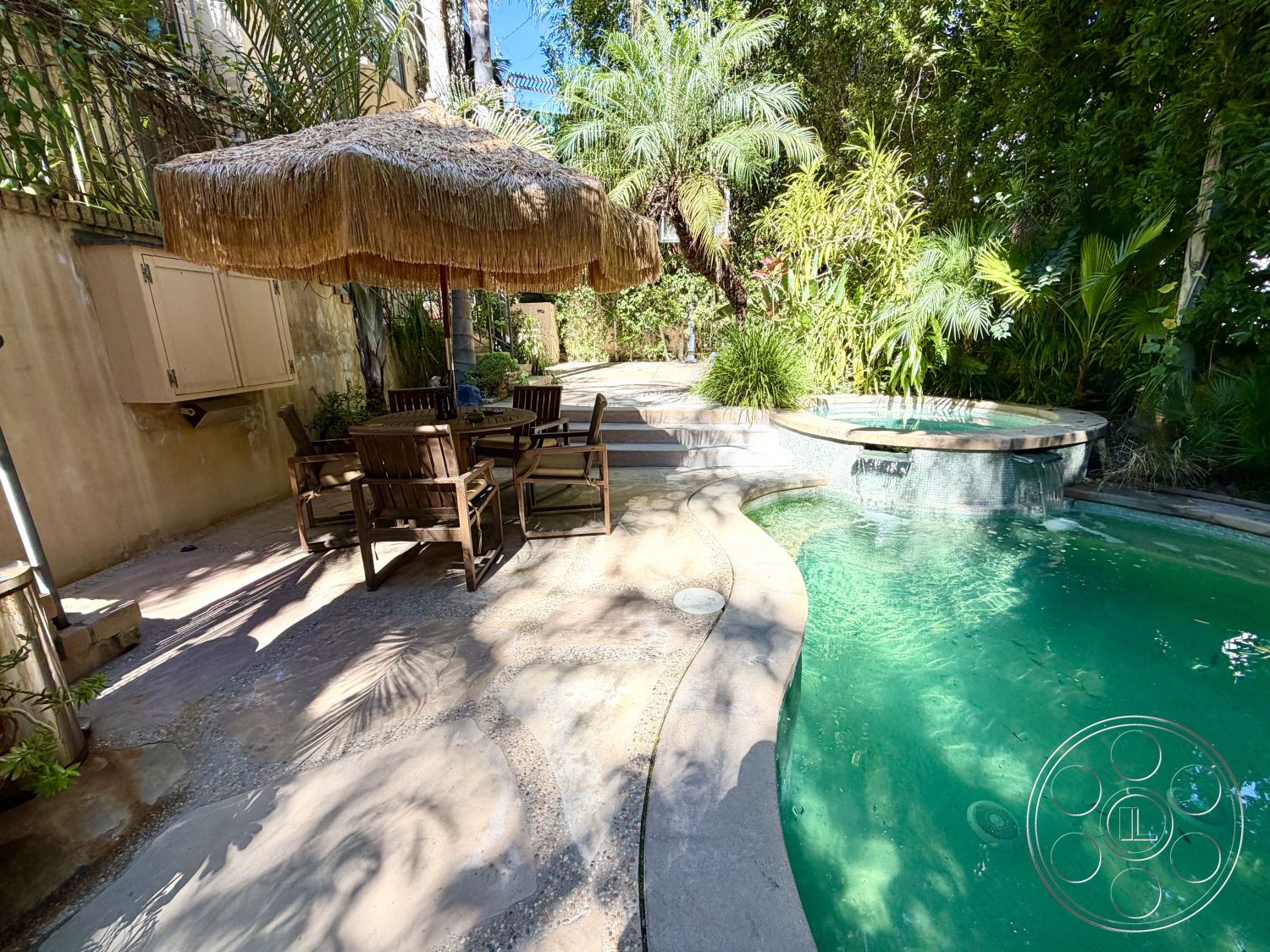 Medit 167 - rectangular swimming pool, garden setting, thatched umbrella, lush tropical landscaping, outdoor relaxation space, textured concrete surface, private garden oasis, natural stone pool deck, palm trees surrounding pool area, exterior concrete patio flooring, smooth concrete steps, wooden outdoor dining set, raised spa with stone coping, patio area with seating, weathered wood furniture finish