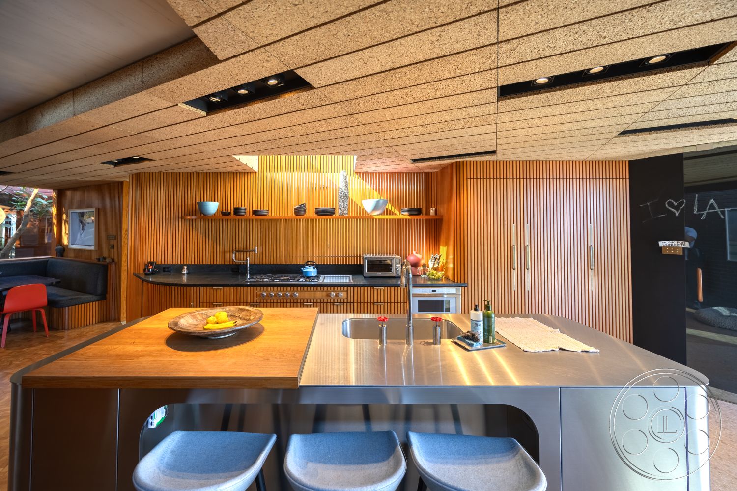 Silvertop House - interior: hardwood flooring, interior: custom cabinetry, exterior: cork ceiling tiles, interior: stainless steel kitchen countertop, interior: vertical wood paneling, interior: open concept kitchen design, interior: minimalist kitchen island, interior: built-in shelves, interior: modern kitchen appliances, interior: geometric light fixtures, interior: ergonomic kitchen seating, interior: seamless transition from kitchen to living area, interior: textured wall treatments, interior: decorative kitchen bowl, interior: large kitchen windows, interior: natural light-infused space, interior: contemporary style, interior: cozy nook with built-in seating, interior: urban loft ambiance