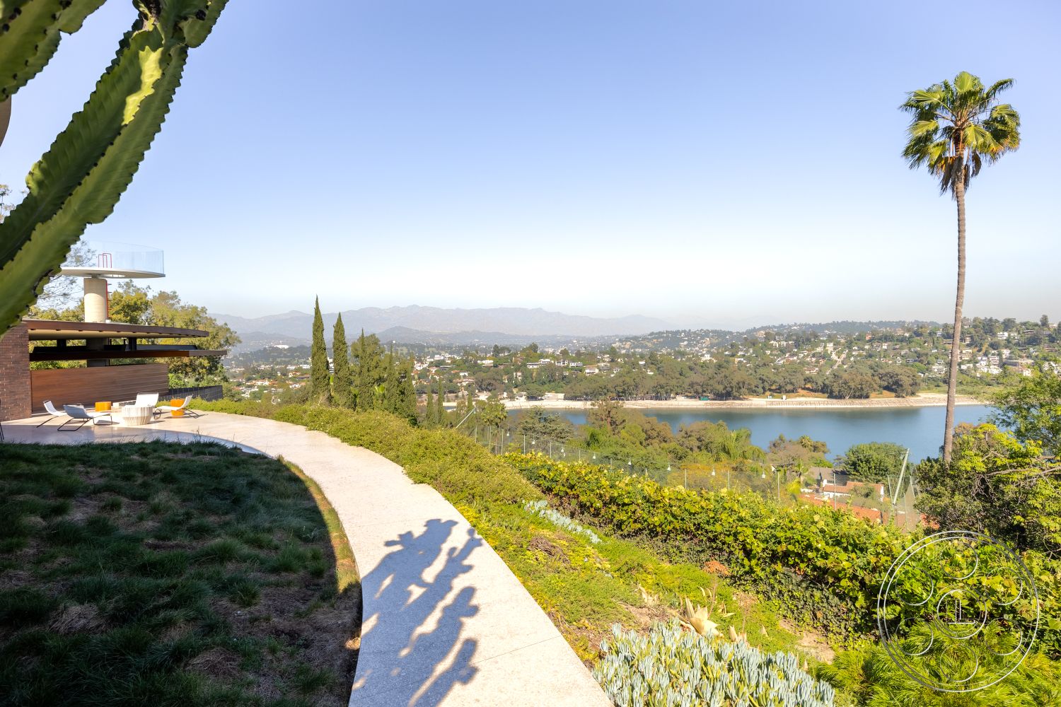 Silvertop House - exterior, modern outdoor furniture, surrounding hillside, landscape lighting, curved concrete pathway, decorative stone borders, landscape with native greenery, flat lawn area, views of city skyline, distressed wood deck