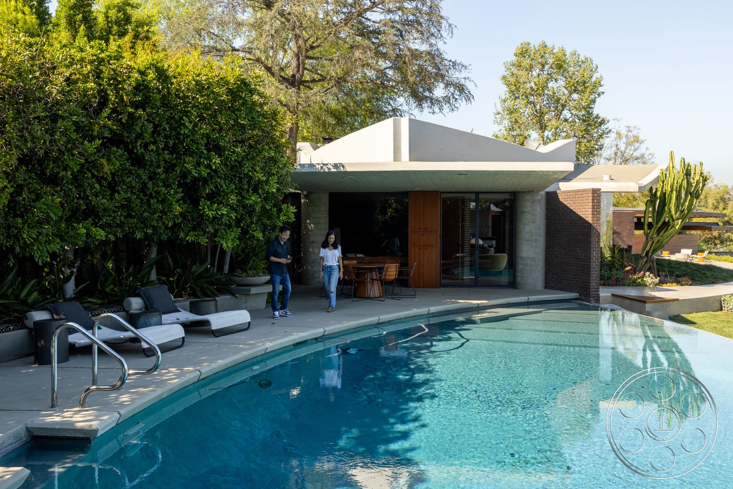 Silvertop House - exterior, flat roof, minimalist design elements, glass sliding doors, contemporary architecture, tropical landscaping, concrete pool deck, curved pool, smooth concrete walls, modern lounge chairs, landscaped garden setting, rectangular patio, wooden outdoor dining set, textured greenery border