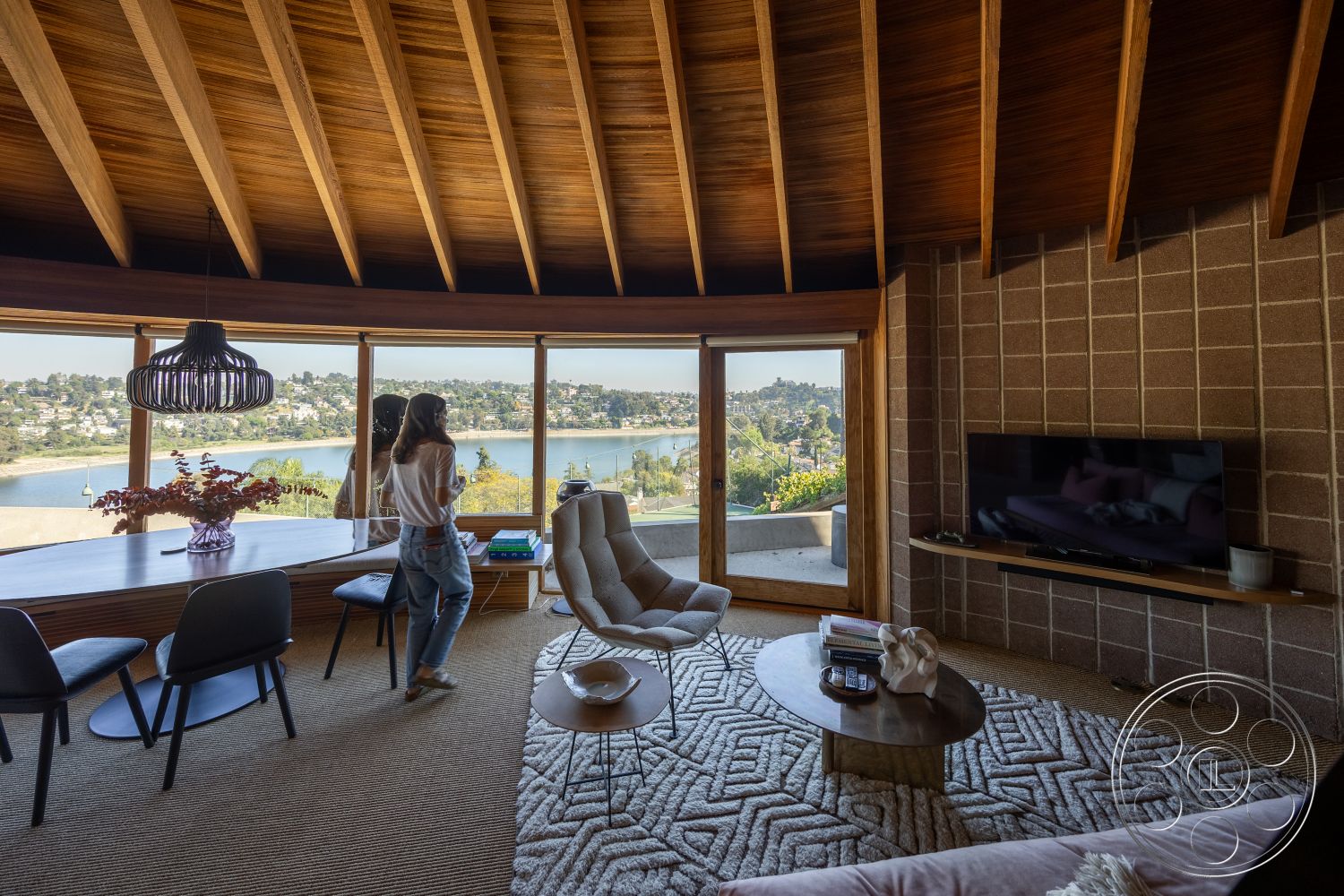 Silvertop House - exposed wood ceiling beams interior, soft neutral color palette interior, contemporary furnishings interior, minimalist coffee table design interior, open floor plan living space interior, large glass windows with lake view interior, concrete block walls interior, textured area rug flooring interior, wooden dining table with modern design interior, modern pendant light fixture interior, curved seating arrangement interior, natural wood accents throughout interior, seamless indoor-outdoor connection interior, sliding patio door interior, lakefront property view interior