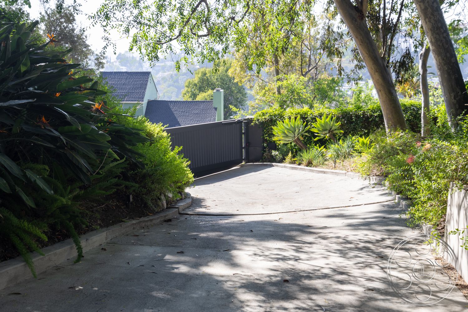 Silvertop House - landscaped garden, tropical plants, gated entrance, concrete driveway, curved driveway, fenced property, hillside location, sunlit pathway, lush greenery surroundings, exterior residential