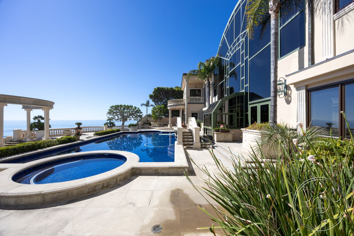 Pacifica Estate - exterior, landscaped garden, palm trees, concrete steps, modern architectural style, infinity pool, concrete pool deck, rectangular pool, outdoor entertaining area, stone patio flooring, oceanfront view, steel railing details, tile pool border, kidney-shaped hot tub, glass facade windows, balustrade with columns