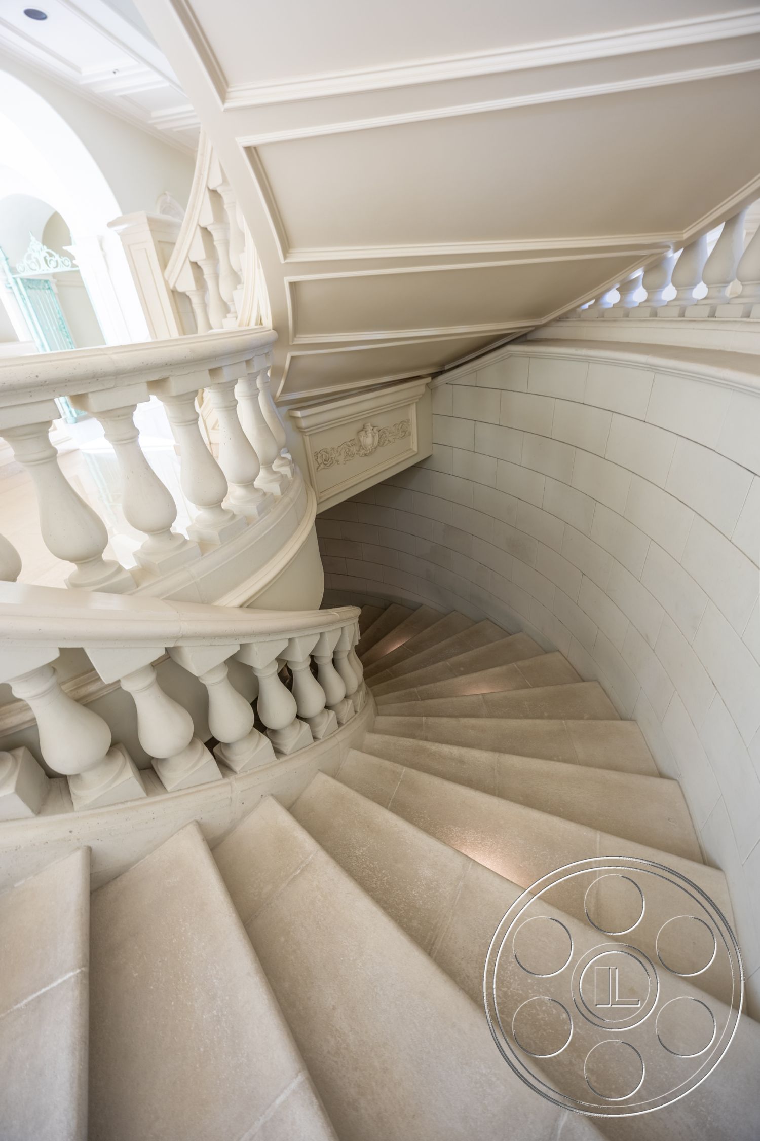 Pacifica Estate - exterior curved staircase, interior elegant staircase design, interior stone stair treads, interior stone balustrade, exterior decorative ceiling details, interior light-colored coffered ceiling, exterior smooth stone wall treatment, interior polished stone landing, exterior classic architectural elements, interior marble staircase design, interior ornate handrail, interior rounded staircase form, exterior decorative molding details, interior spacious atrium view