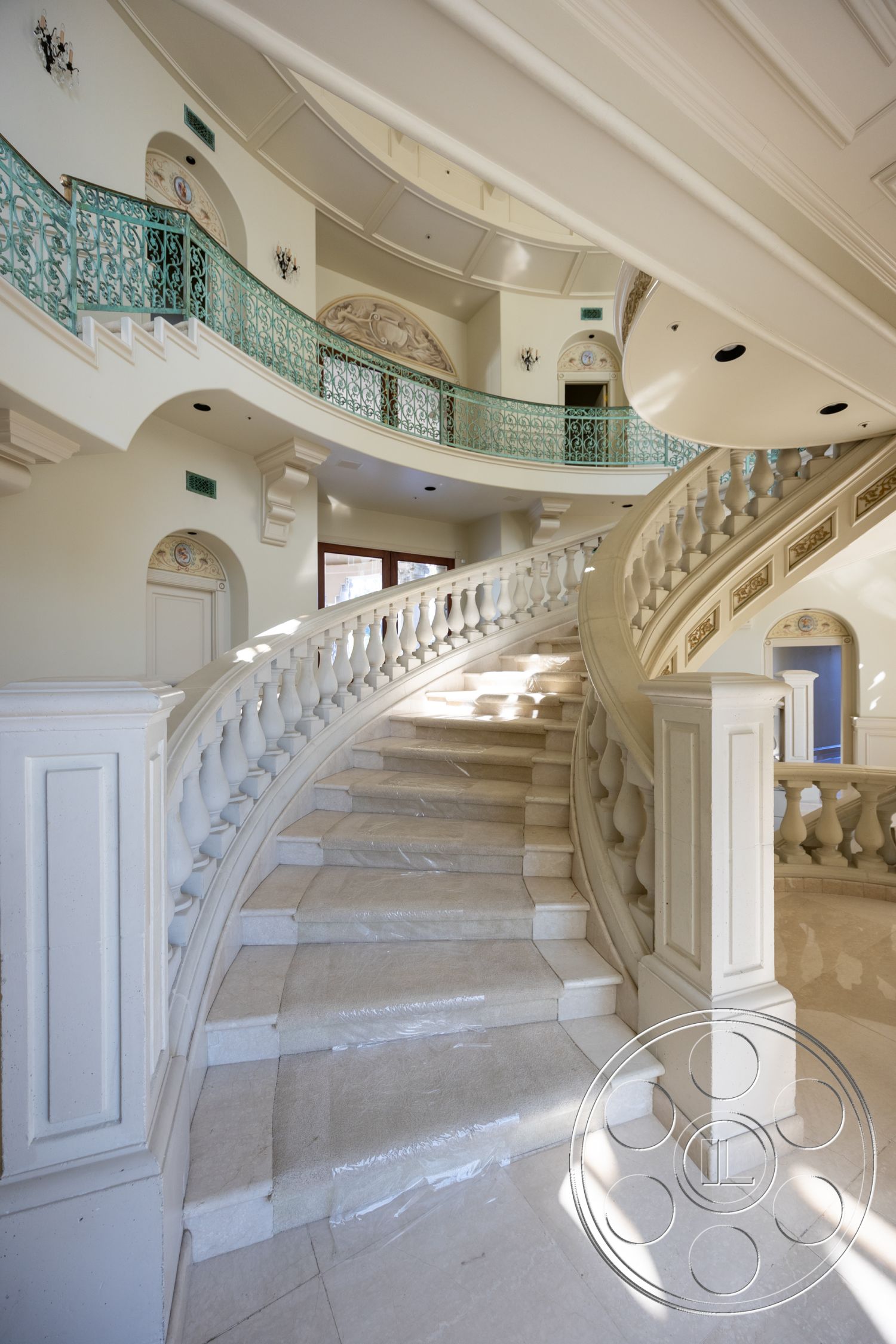 Pacifica Estate - interior open layout, interior coffered ceiling, interior decorative wall moldings, interior textured ceiling details, interior stone floor tiles, interior curved staircase, interior marble staircase, interior arched doorways, interior ornate railing, interior plaster wall finish, interior natural light features, interior wall alcoves, interior luxury home design, interior elegant architectural details