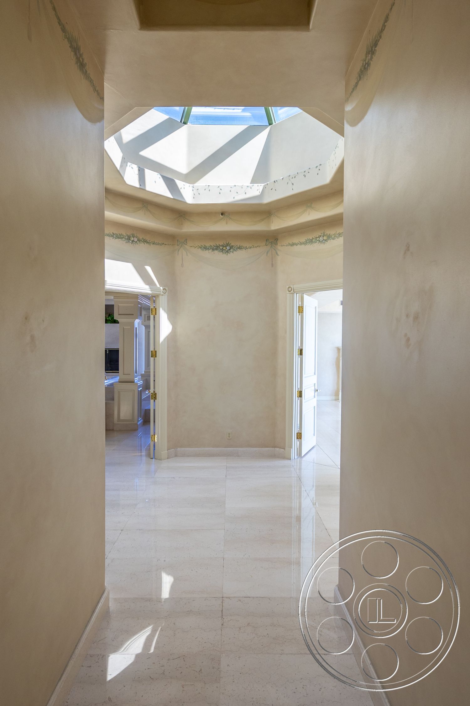 Pacifica Estate - interior textured plaster walls, interior open floor plan, interior marble flooring, interior spacious hallway, interior bright natural light, interior modern luxury design, interior polished marble tile floors, interior octagonal skylight ceiling, interior subtle floral wall decor, interior double doors, interior luxurious ambiance