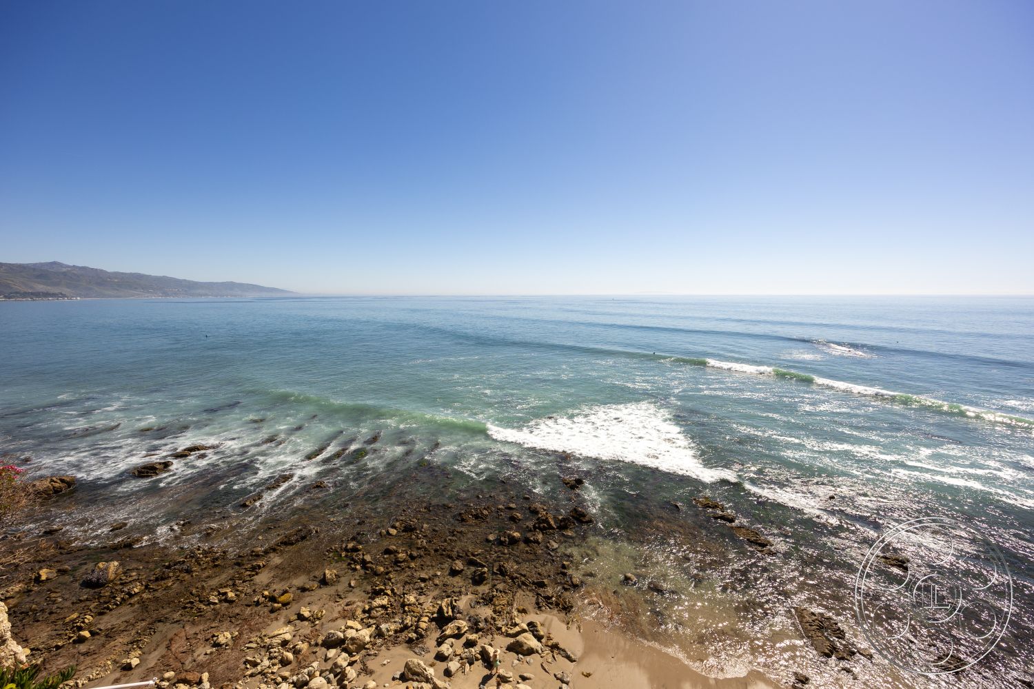 Pacifica Estate - clear blue sky, coastal landscape, rocky shoreline, hillside location, outdoor environment, oceanfront view, suburban beachfront property, sandy beach area, natural coastal terrain, calm ocean waves, southern California beach, sunlit coastal area, seaside ambiance