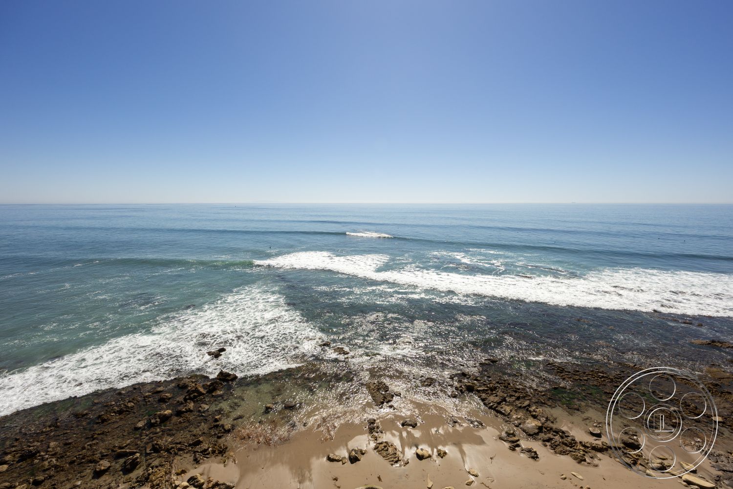 Pacifica Estate - casual outdoor space, clear blue sky, marine environment, oceanfront setting, horizon view, sandy beach shoreline, rocky coastal beach, gentle ocean waves, sunny beach atmosphere, natural seaside landscape, surf-friendly waters, warm coastal climate, beachfront relaxation area, saltwater ocean view, tide pool rocks, sunny seaside, natural shoreline, tranquil ocean scene