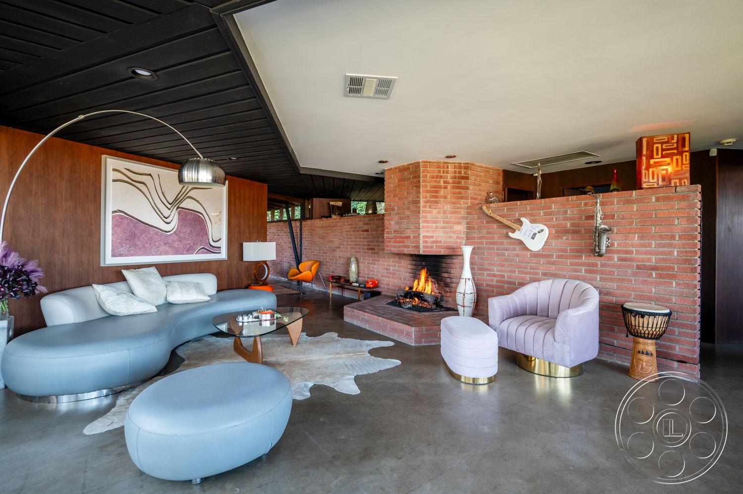 Retro 31 - modern furnishings, unique lighting fixtures, modern coffee table, open concept living space, textured wall finishes, dark wood paneling walls, exposed brick fireplace wall, natural lighting from large windows, recessed lighting in ceiling, soft seating area, interior warm color palette, curved leather sofa, contemporary decor elements, minimalist floor lamp, vaulted ceiling with wood beams, concrete living room flooring, geometric art wall decor, iconic accent chairs, animal hide rug, functional fireplace design, stylish ceramic accents