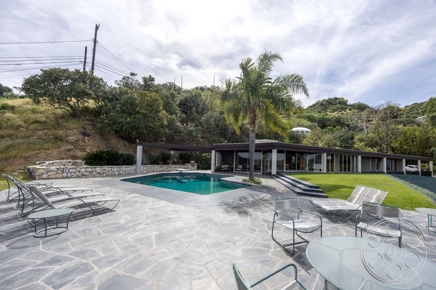 Retro 19 - exterior, glass sliding doors, surrounding greenery, low-maintenance garden, floor-to-ceiling windows, open-concept living space, outdoor lounge area, rectangular pool, flat roof design, contemporary architectural style, aluminum outdoor furniture, landscaped hillside setting, slate stone patio flooring, poolside natural stone walls, paving stone border